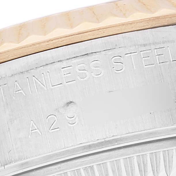 This is a close-up view of the side of a Rolex Datejust 79173 Women's Steel and Gold (two tone) Mother of Pearl Dial 79173 Women's Steel and Gold (two tone) Mother of Pearl Dial watch, showing part of the bezel and "STAINLESS STEEL" engraving.