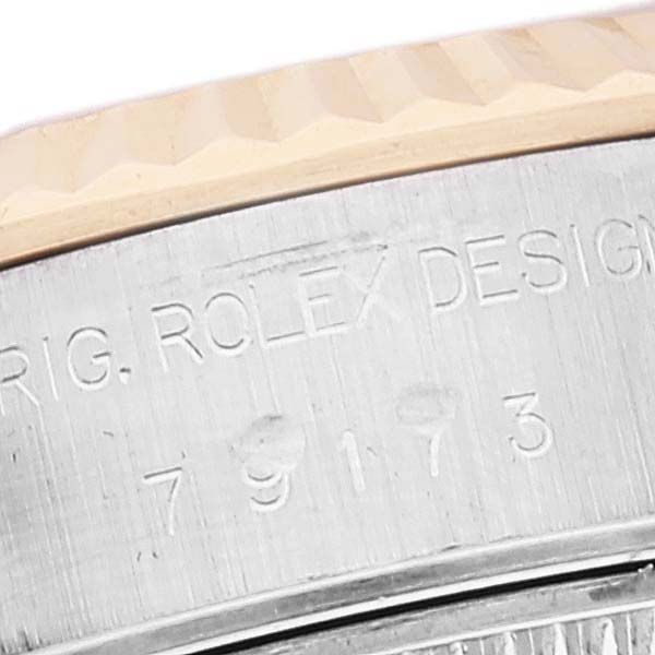 The image shows a close-up of the case side of a Rolex Datejust 79173 Women's Steel and Gold (two tone) Mother of Pearl Dial 79173 Women's Steel and Gold (two tone) Mother of Pearl Dial, highlighting the engraved model number and fluted bezel.