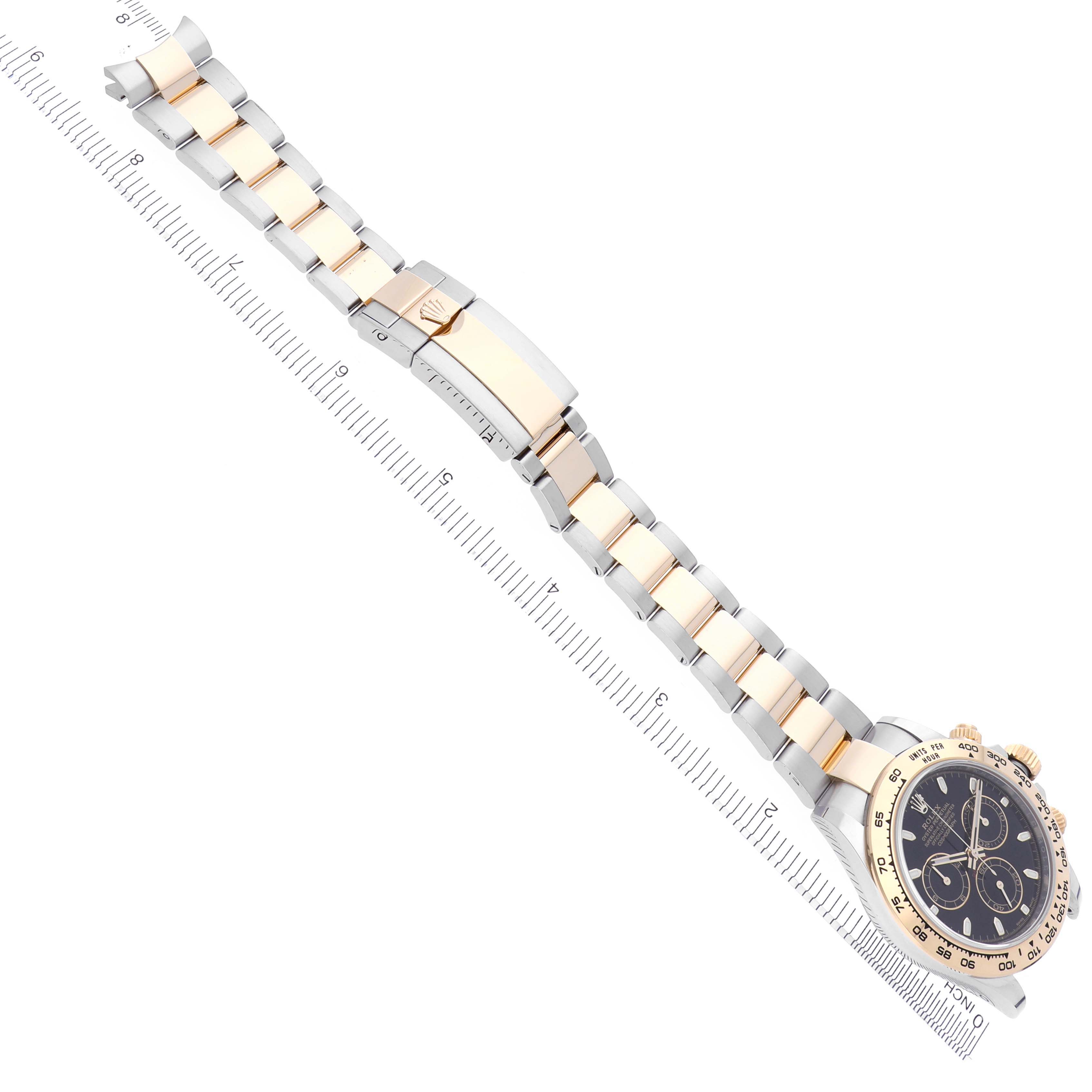 The Rolex Daytona 116503-0004 Men's Steel and Gold (two tone) Black Dial 116503-0004 Men's Steel and Gold (two tone) Black Dial watch is shown at an angle displaying the bracelet, clasp, and partial face.