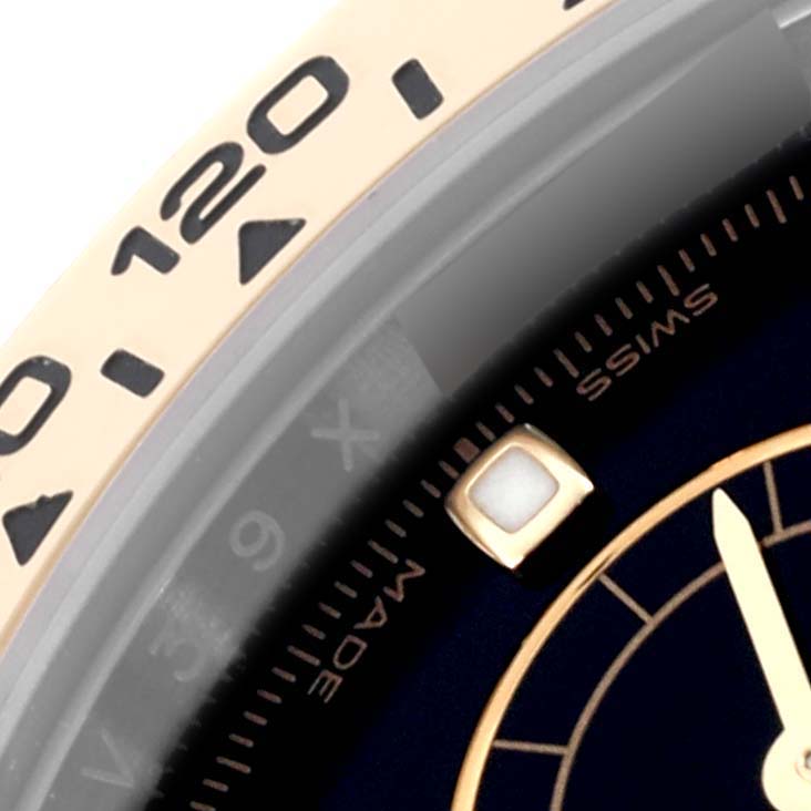 The image shows a close-up of the Rolex Daytona 116503-0004 Men's Steel and Gold (two tone) Black Dial 116503-0004 Men's Steel and Gold (two tone) Black Dial, focusing on the bezel and a portion of the dial with a marker and hands.