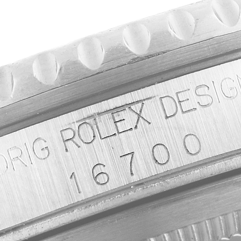 The image shows a close-up of the model number "16700" and "ROLEX DESIGN" engraving on the side of the Rolex GMT-Master 16700 Men's Stainless Steel Black Dial 16700 Men's Stainless Steel Black Dial watch case.