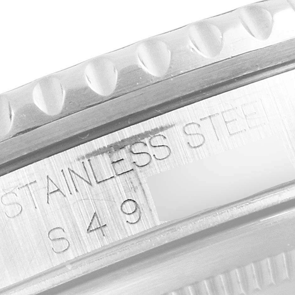 The image shows a close-up of the engraving and bezel teeth of a Rolex GMT-Master 16700 Men's Stainless Steel Black Dial 16700 Men's Stainless Steel Black Dial watch, highlighting "STAINLESS STEEL."