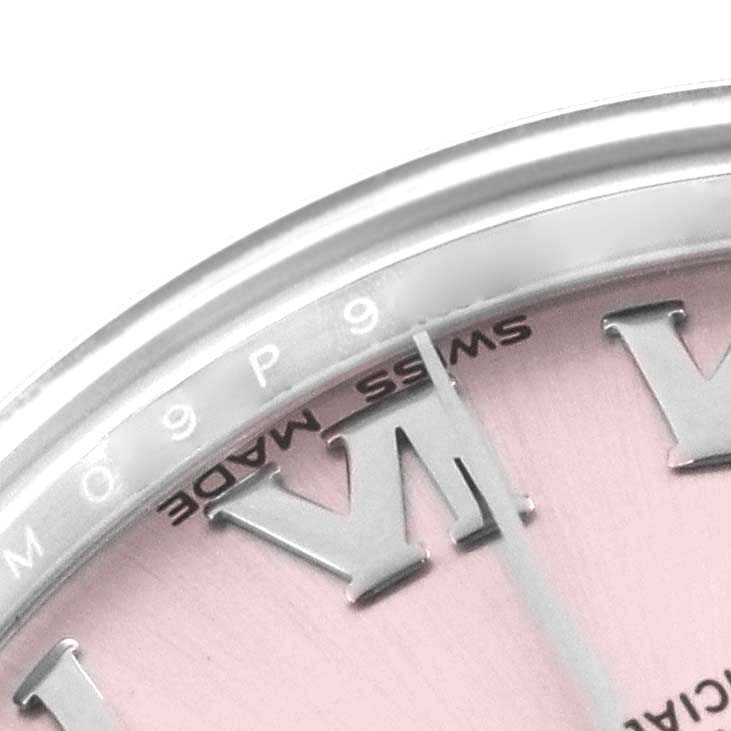 The image shows a close-up of the dial and bezel of a mid-size Rolex watch, highlighting part of the Roman numeral and markers.