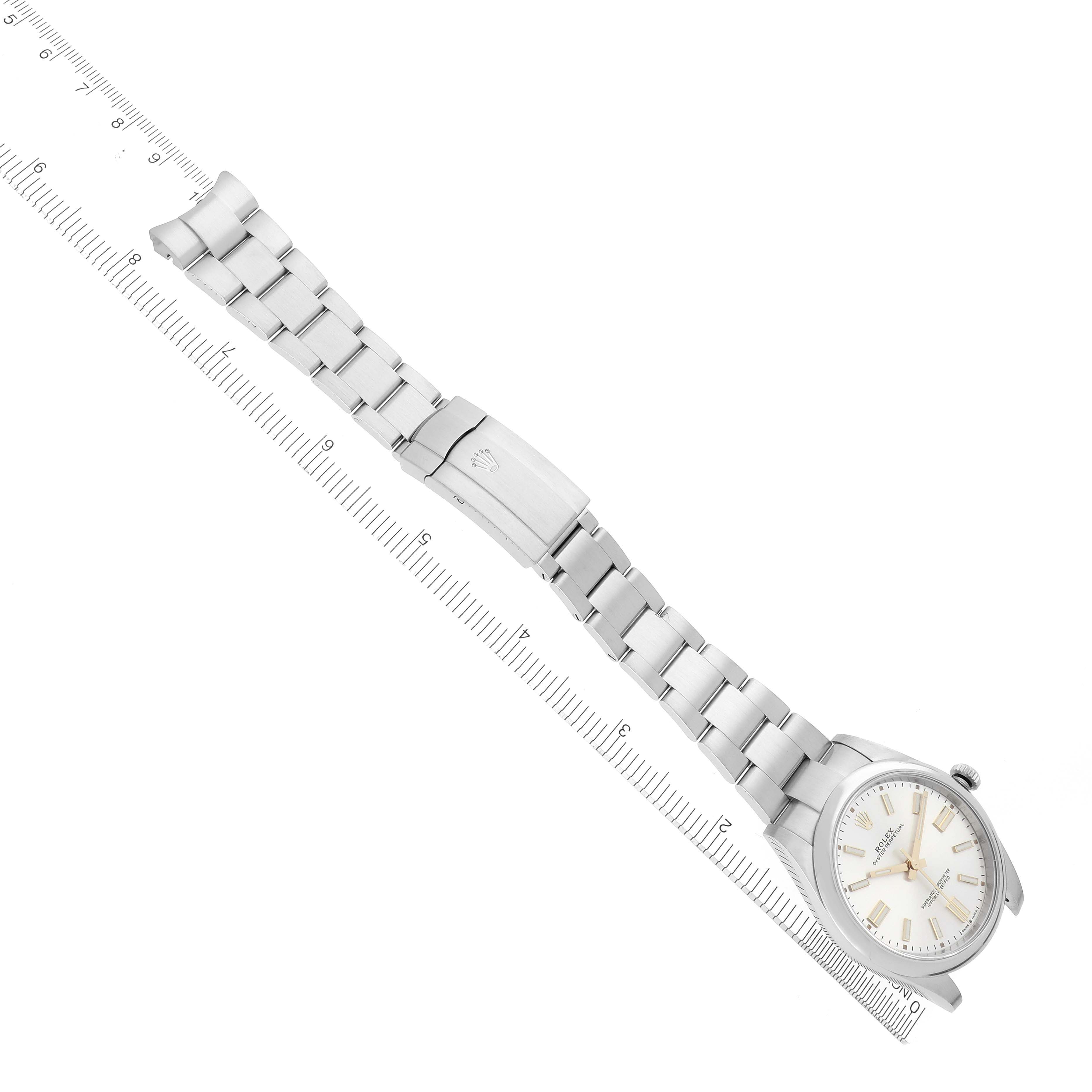 The Rolex Oyster Perpetual 124300 Men's Stainless Steel Silver Dial 124300 Men's Stainless Steel Silver Dial watch is shown from a top view, displaying the dial, case, and bracelet alongside a ruler.