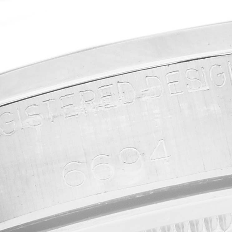 This close-up image shows the engraved serial number 6694 on the case of a Vintage Collection Rolex watch.