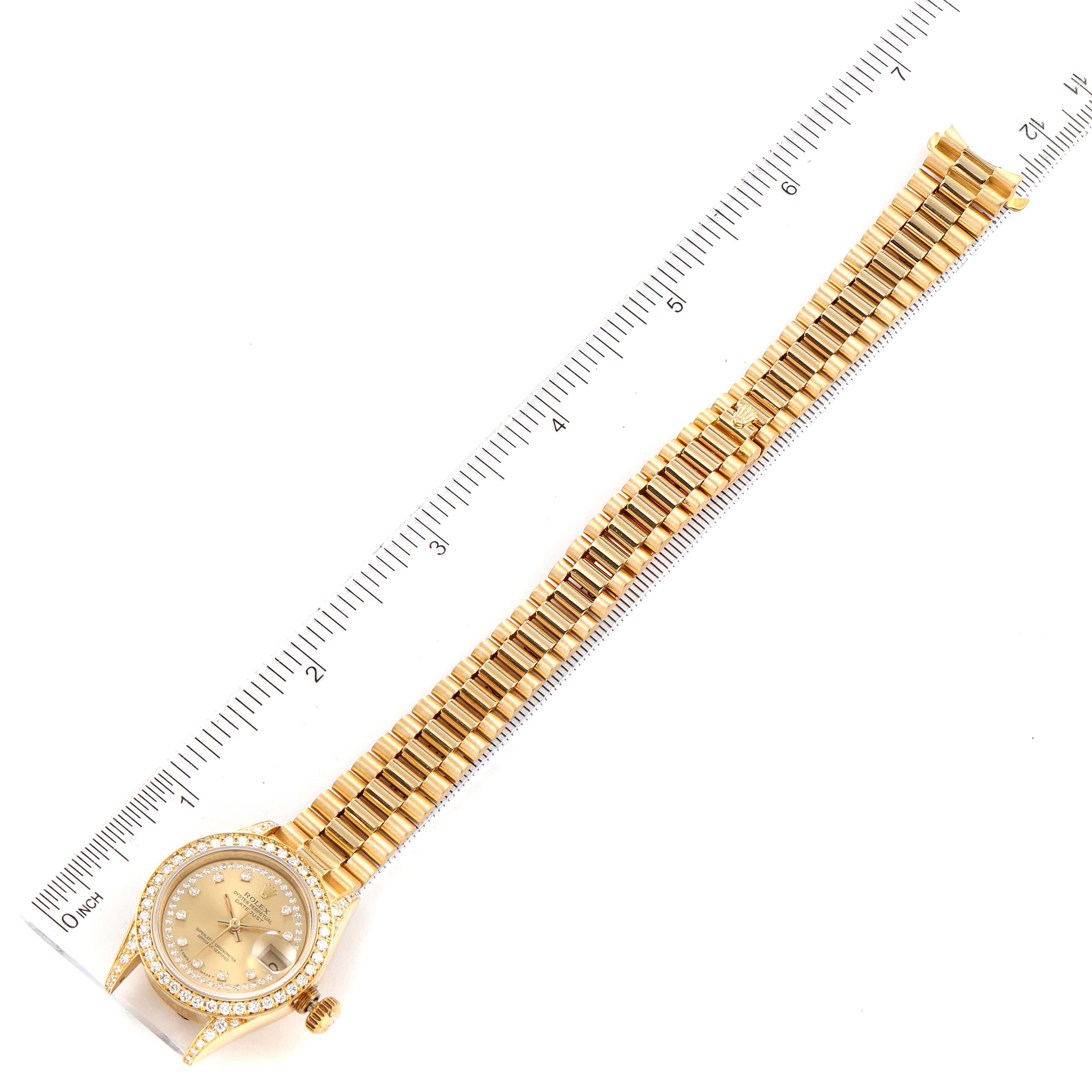 This is a top-view image of a Rolex President 69158 Women's Yellow Gold Champagne Dial 69158 Women's Yellow Gold Champagne Dial model watch, showing the face, bezel, crown, and full strap with a ruler for scale.