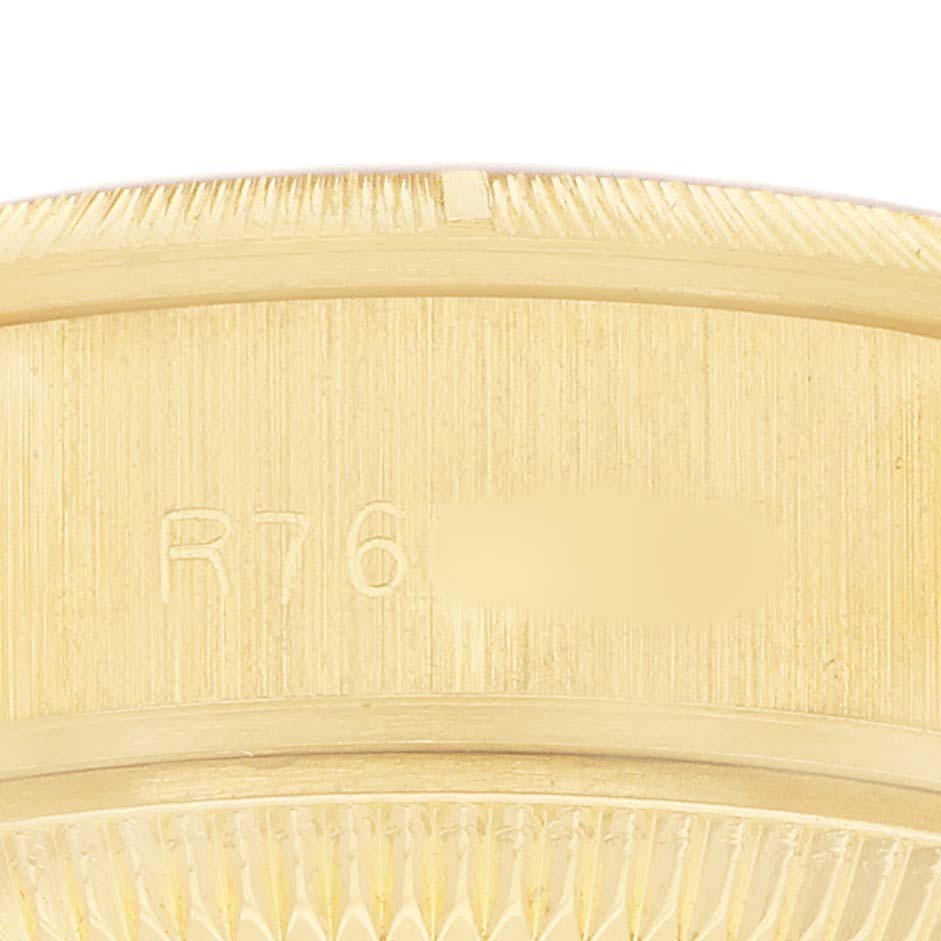 The image shows a close-up of the gold fluted bezel and engraved serial number of a Rolex President 69278 Women's Yellow Gold Champagne Dial watch.