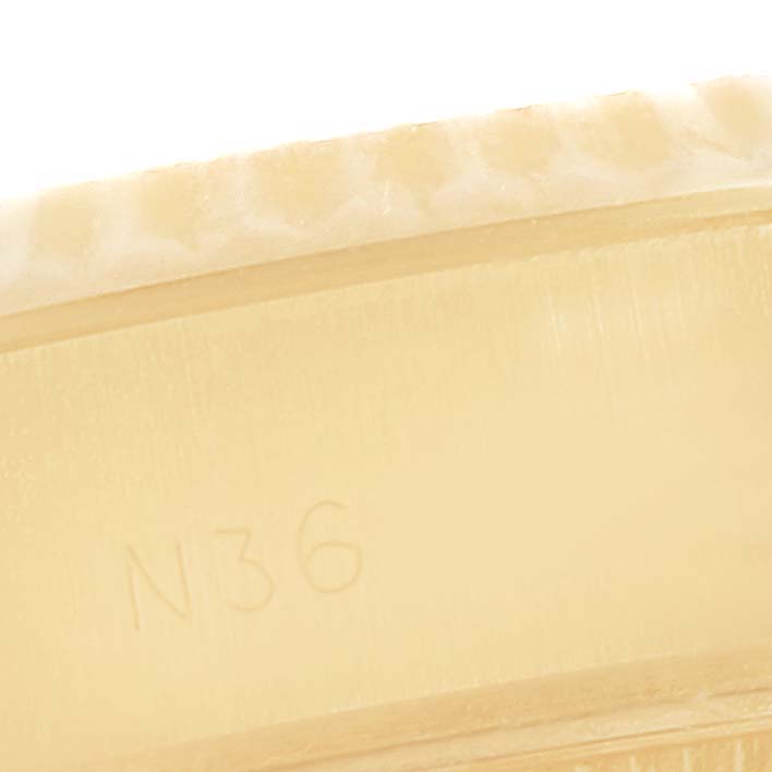 This close-up image of the Rolex President 69178 Women's Yellow Gold Champagne Dial 69178 Women's Yellow Gold Champagne Dial model shows the watch's bezel and a partial engraving.