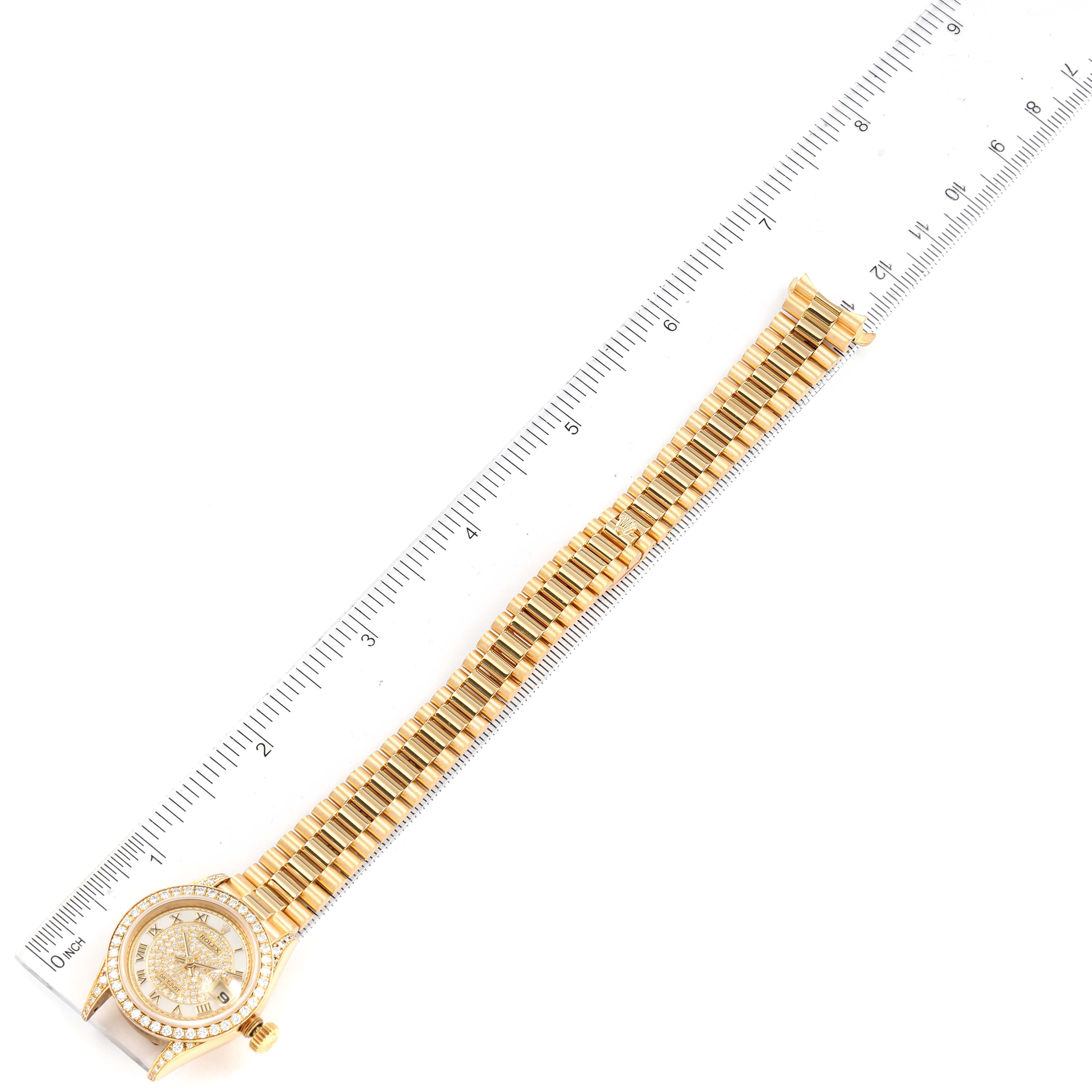 The image shows a top-down view of the Rolex President 69158 Women
s Yellow Gold Mother of Pearl Dial 69158 Women
s Yellow Gold Mother of Pearl Dial watch alongside a ruler for size reference.