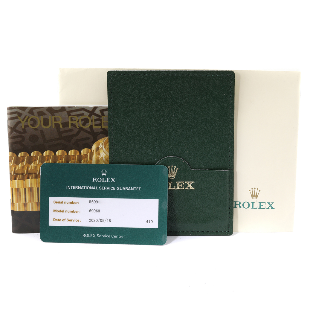 The image shows the accessories of a Rolex President 69068 Women
s Yellow Gold Champagne Dial 69068 Women
s Yellow Gold Champagne Dial model, including the warranty card, booklet, and leather card holder.