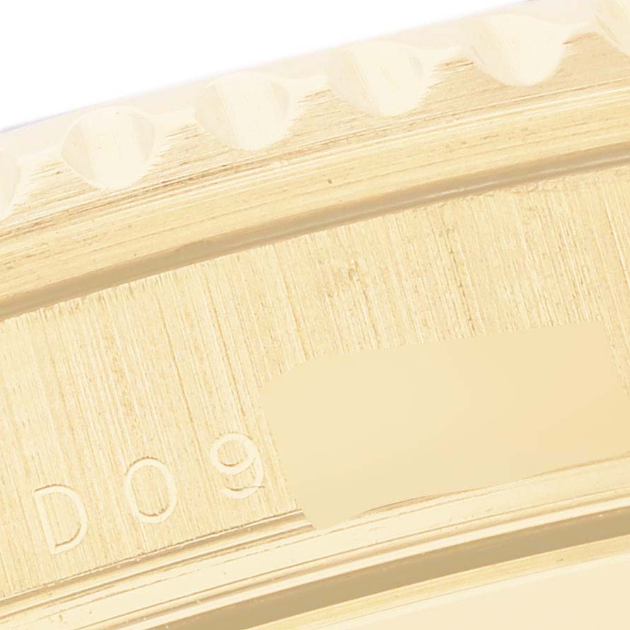The image shows a close-up of the edge and engravings on the Rolex Submariner 16618 Men's Yellow Gold Blue Dial 16618 Men's Yellow Gold Blue Dial’s gold bezel.