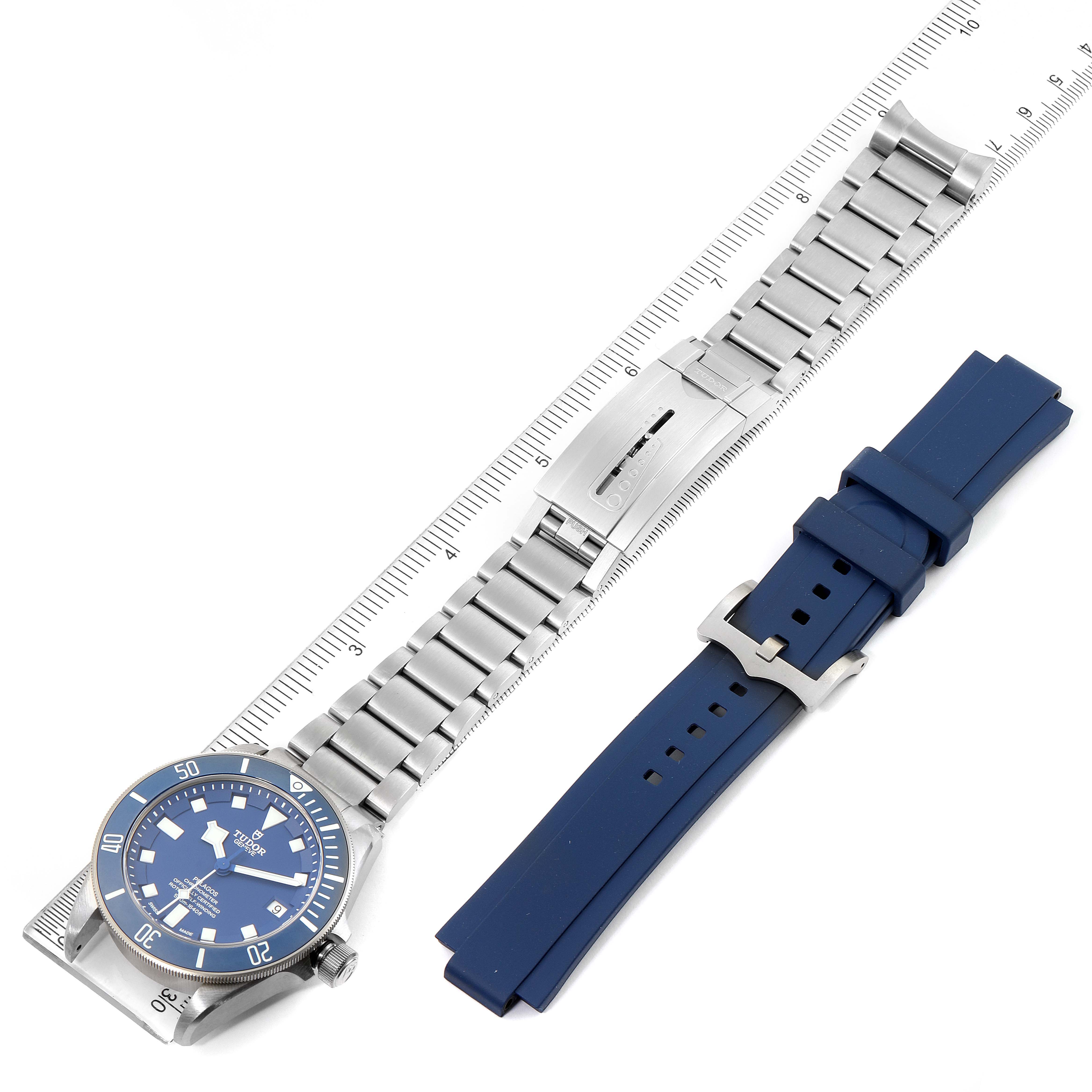 This image shows the Tudor Pelagos 25600TV Men's Titanium Blue Dial 25600TV Men's Titanium Blue Dial watch lying flat with a metal bracelet and an additional blue rubber strap beside it.
