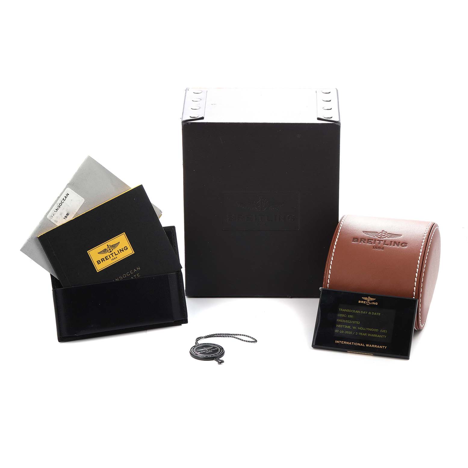 The image shows Breitling Transocean R45310 Men
s Rose Gold Silver Dial accessories including a box, leather case, booklets, and a warranty card set neatly.