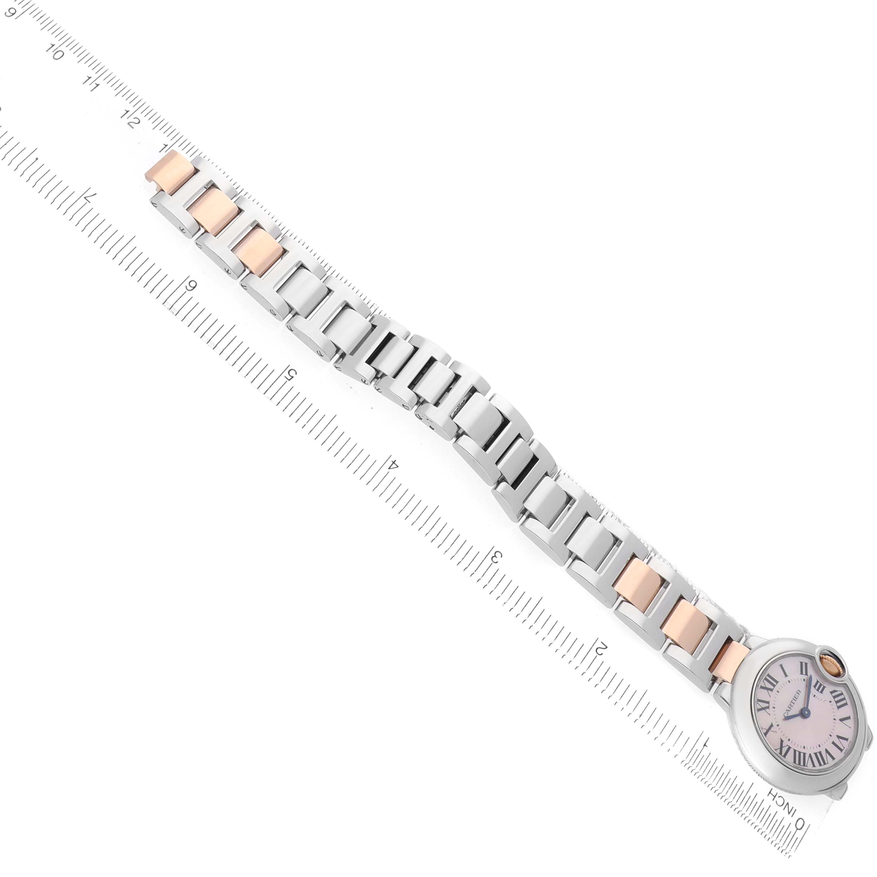 The Cartier Ballon Bleu W6920034 Women's Steel and Gold (two tone) Mother of Pearl Dial watch is shown from above, highlighting the face and metal bracelet against a measuring ruler.