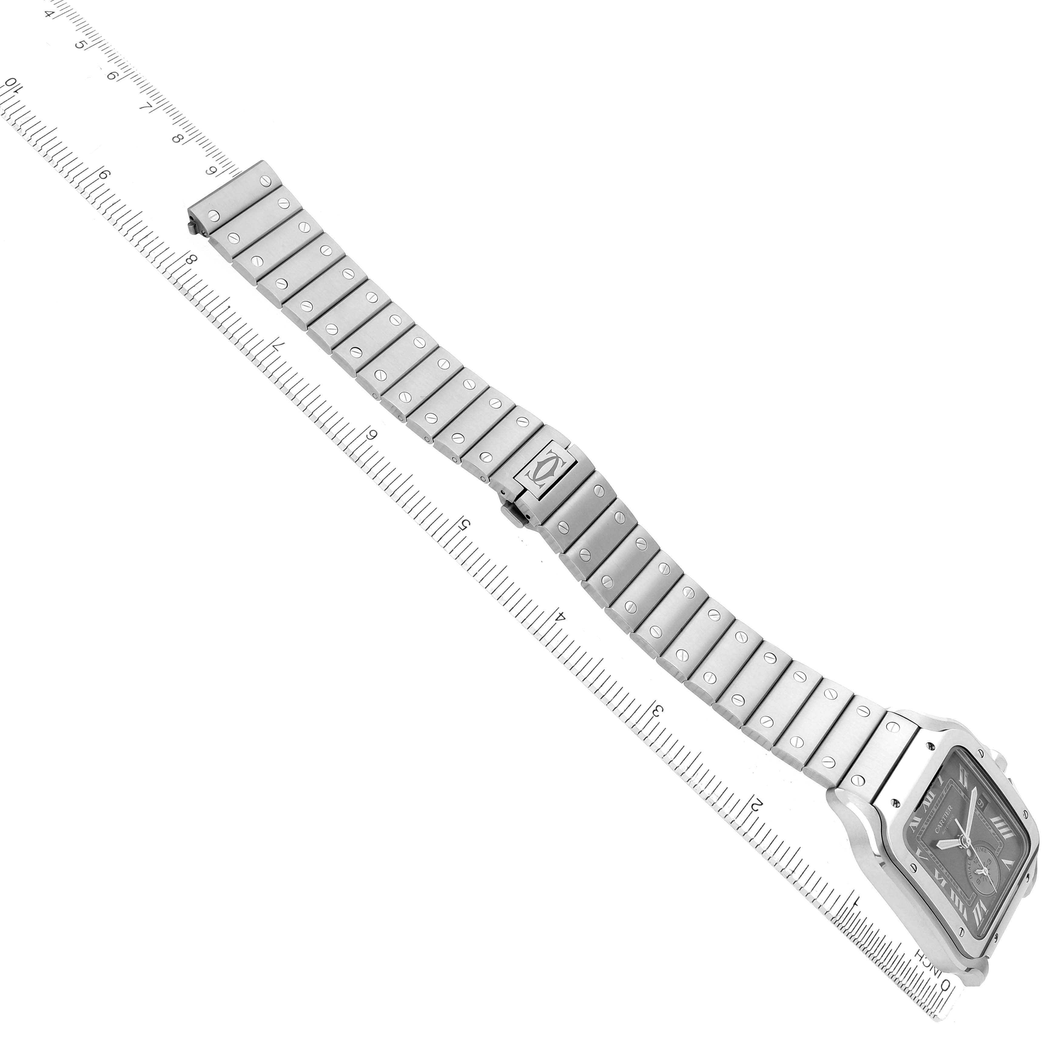 The Cartier Santos WSSA0076 Men's Stainless Steel Grey Dial watch is angled diagonally, showing the face, bracelet, and clasp with a ruler underneath.