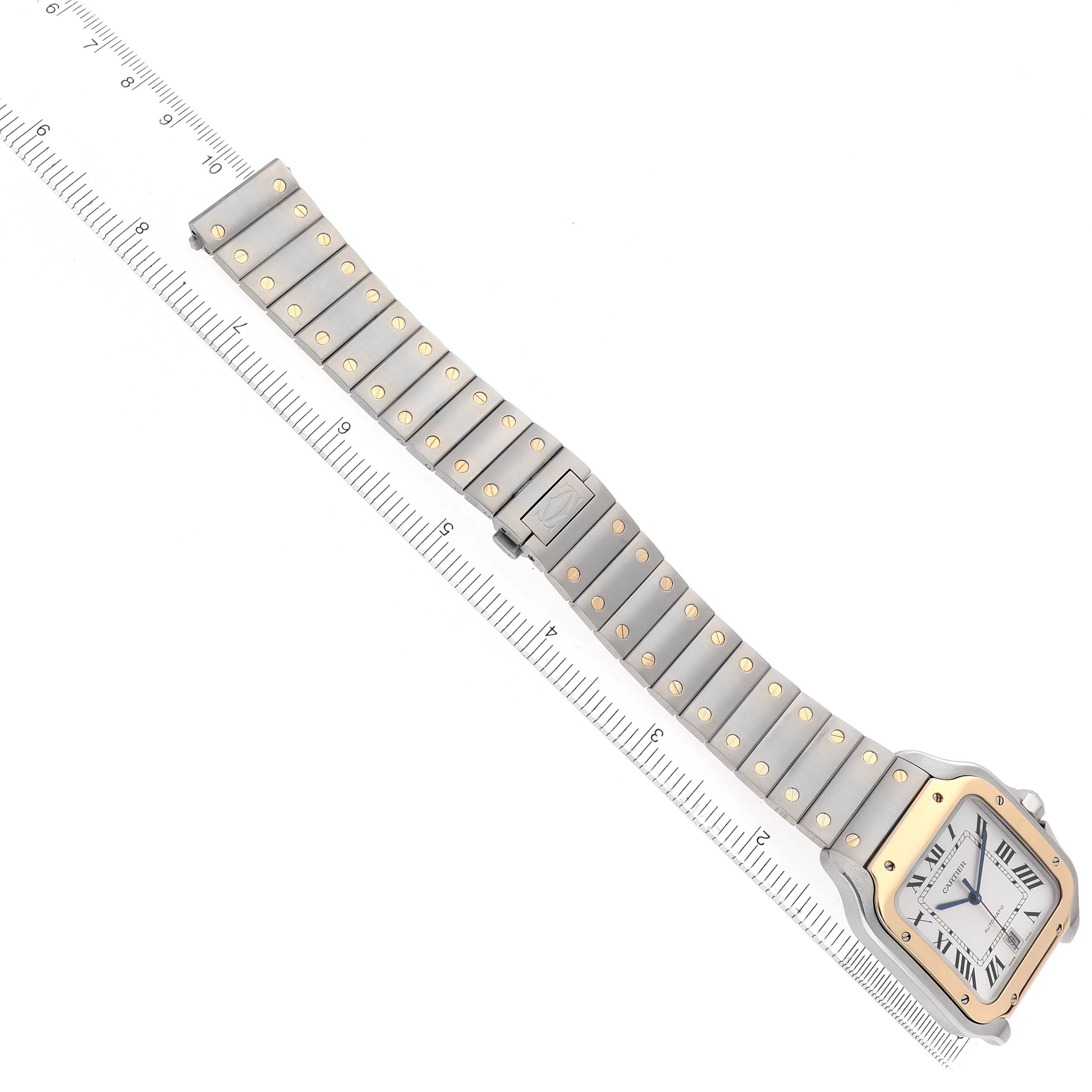 The Cartier Santos W2SA0006 Men's Steel and Gold (two tone) Silver Dial watch is shown from a top-down angle, displaying the face, bezel, and full bracelet with rulers beside it.
