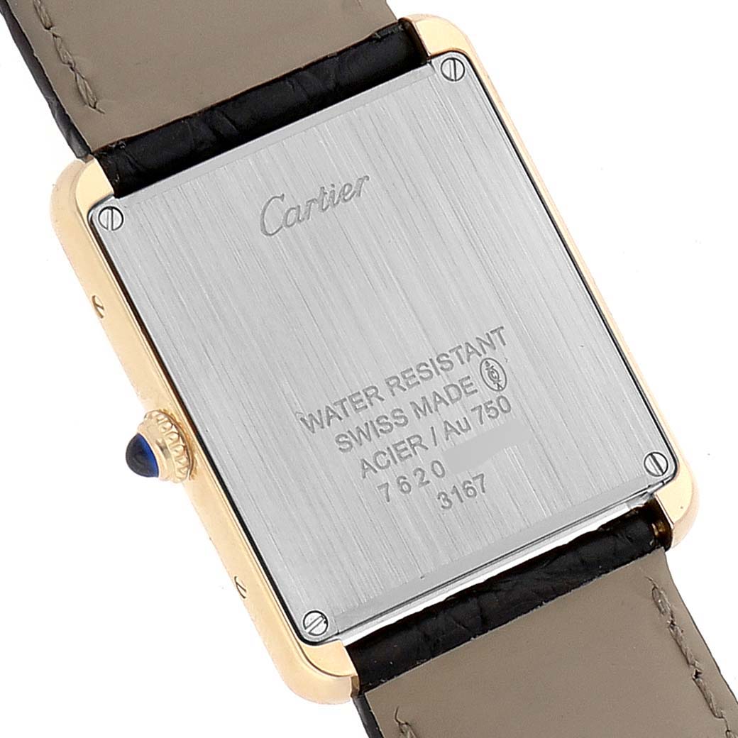 The image shows the back case and strap of a Cartier Tank Solo W5200004 Men
s Steel and Gold (two tone) Silver Dial W5200004 Men
s Steel and Gold (two tone) Silver Dial watch, highlighting its inscriptions and screws.