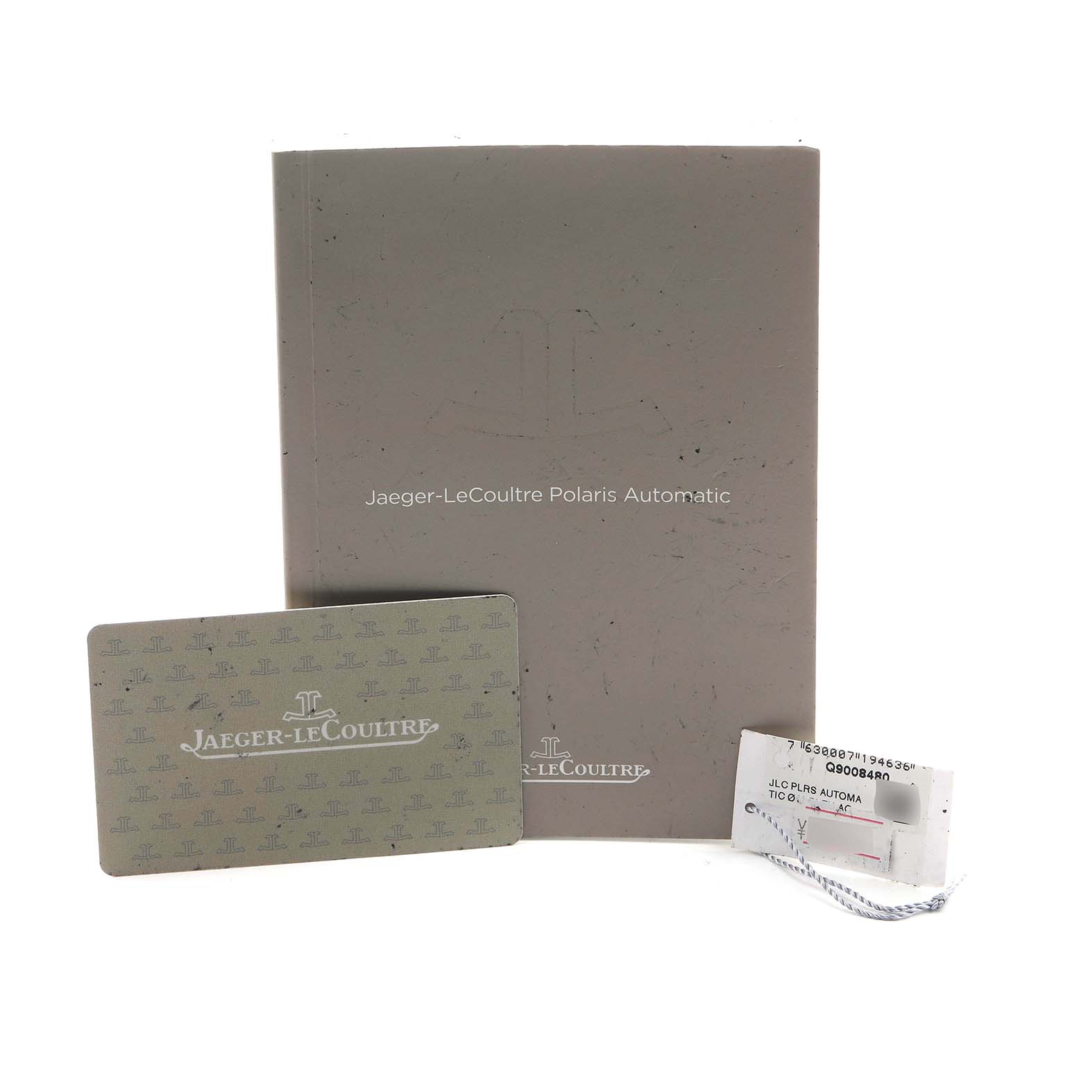 The image shows a Jaeger-LeCoultre Polaris booklet, warranty card, and a tag from a top-down angle.