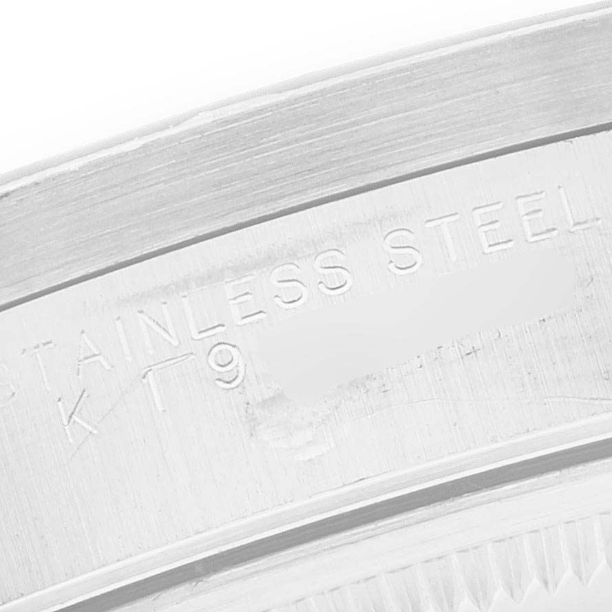 The image shows a close-up of the edge of the case back of a Rolex Date 15210 Men's Stainless Steel Black Dial 15210 Men's Stainless Steel Black Dial model watch, highlighting the "STAINLESS STEEL" marking.