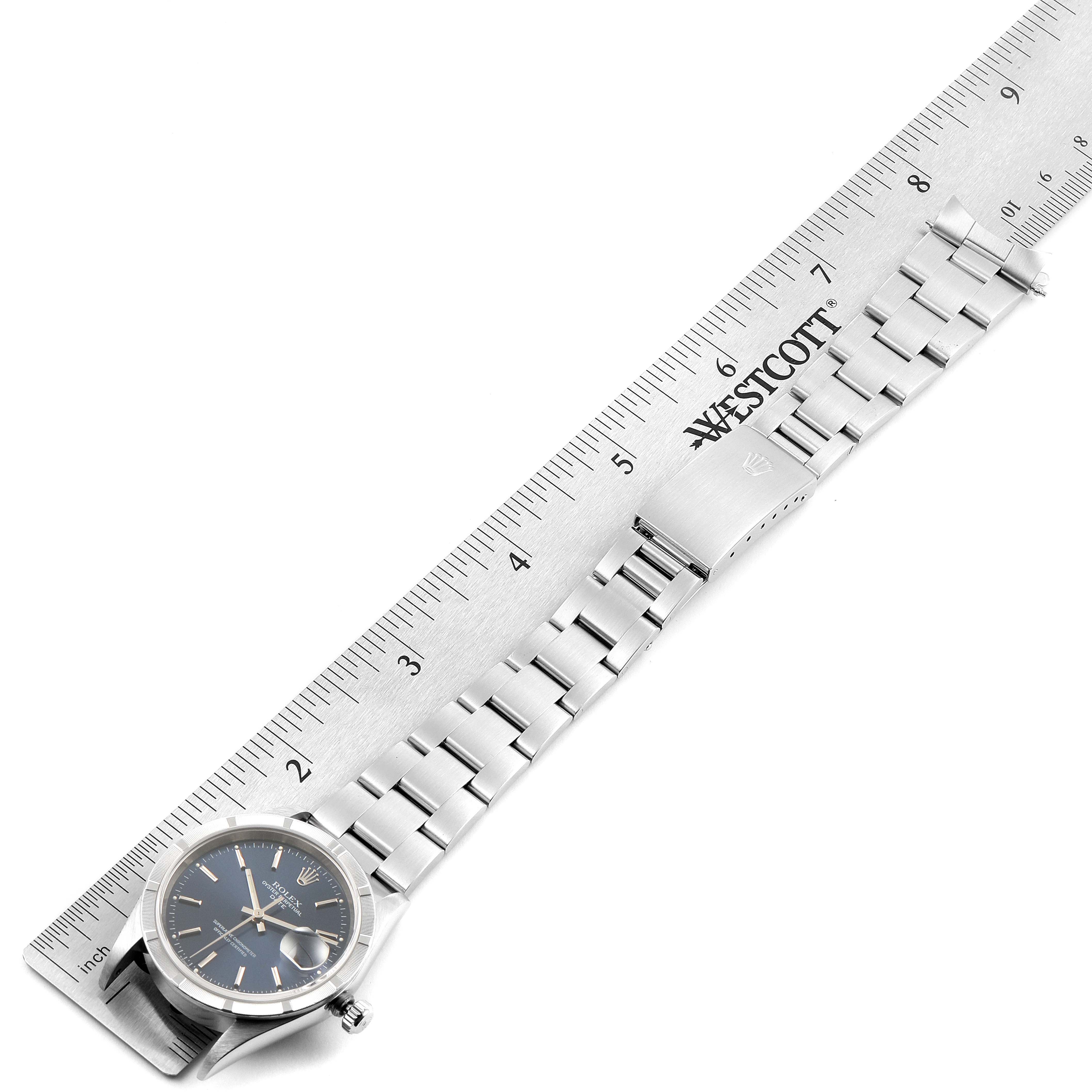 The image shows the Rolex Date 15210 Men's Stainless Steel Blue Dial 15210 Men's Stainless Steel Blue Dial model watch laid flat next to a ruler, displaying the full bracelet and dial.