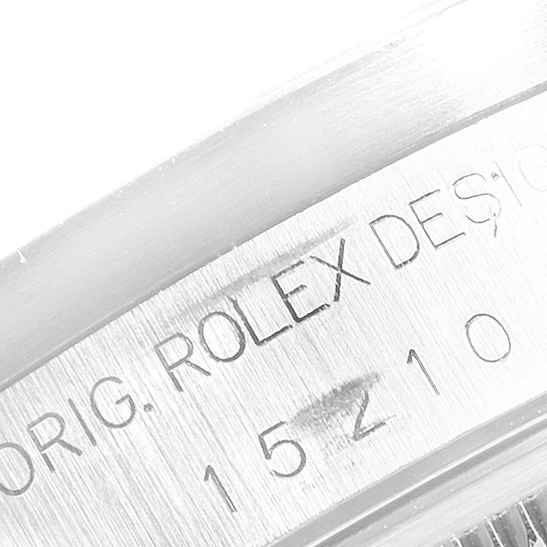 This is a close-up of the side of the Rolex Date 15210 Men's Stainless Steel Blue Dial 15210 Men's Stainless Steel Blue Dial model, showing engraved text and part of the reference number.