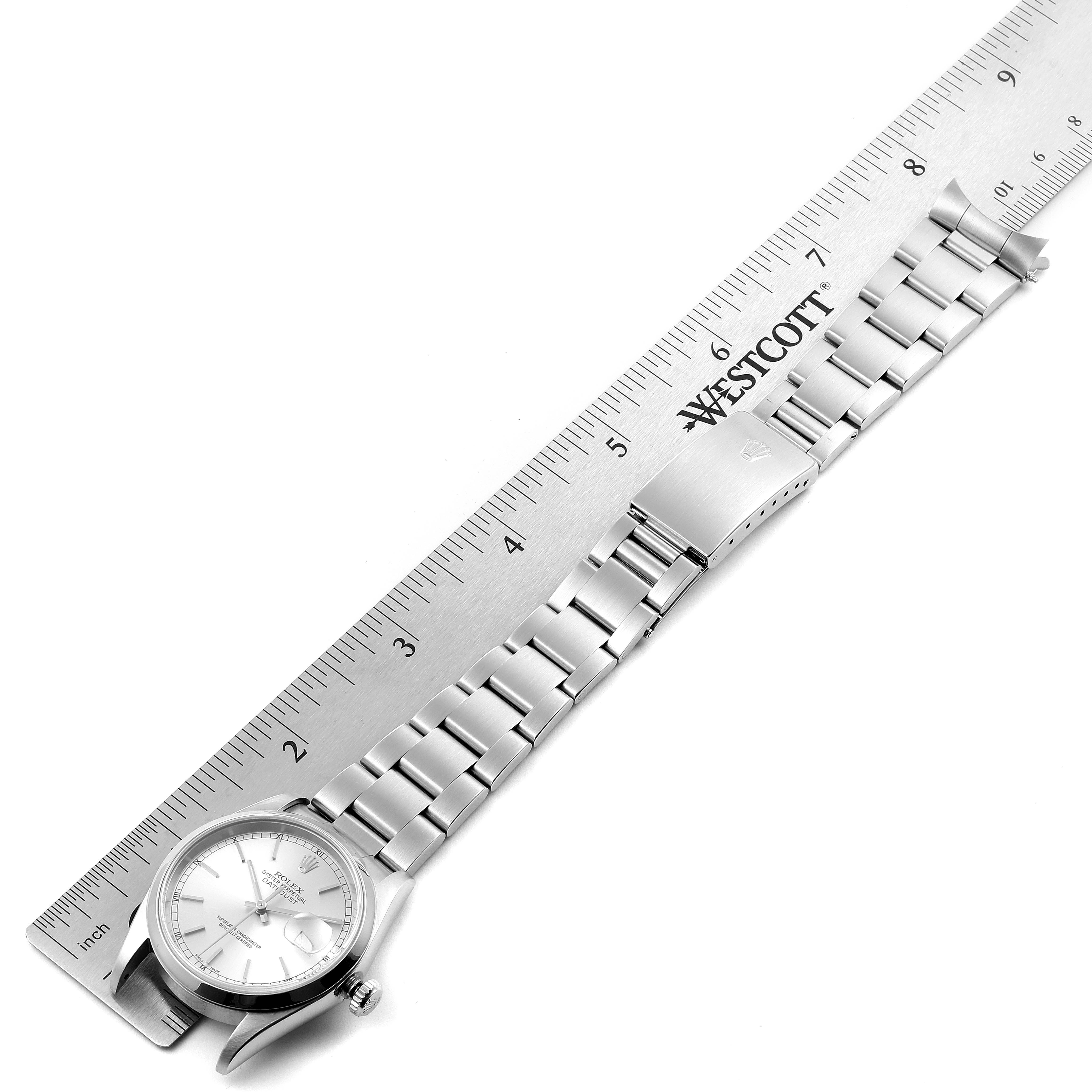 This image shows a top-down view of a Rolex Datejust 16200 Men's Stainless Steel Silver Dial 16200 Men's Stainless Steel Silver Dial watch with the bracelet extended next to a ruler for measurement.