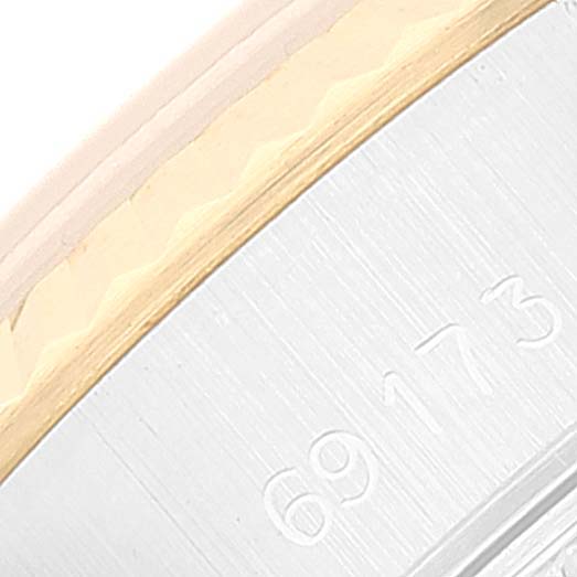 This close-up image shows the serial number on the edge of a Rolex Datejust 69173 Women's Steel and Gold (two tone) White Dial 69173 Women's Steel and Gold (two tone) White Dial watch case with part of the fluted bezel visible.