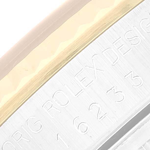 This image shows a close-up of the side engraving on the Rolex Datejust 16233 Men's Steel and Gold (two tone) White Dial 16233 Men's Steel and Gold (two tone) White Dial watch, featuring the serial number and "Rolex Design" text.