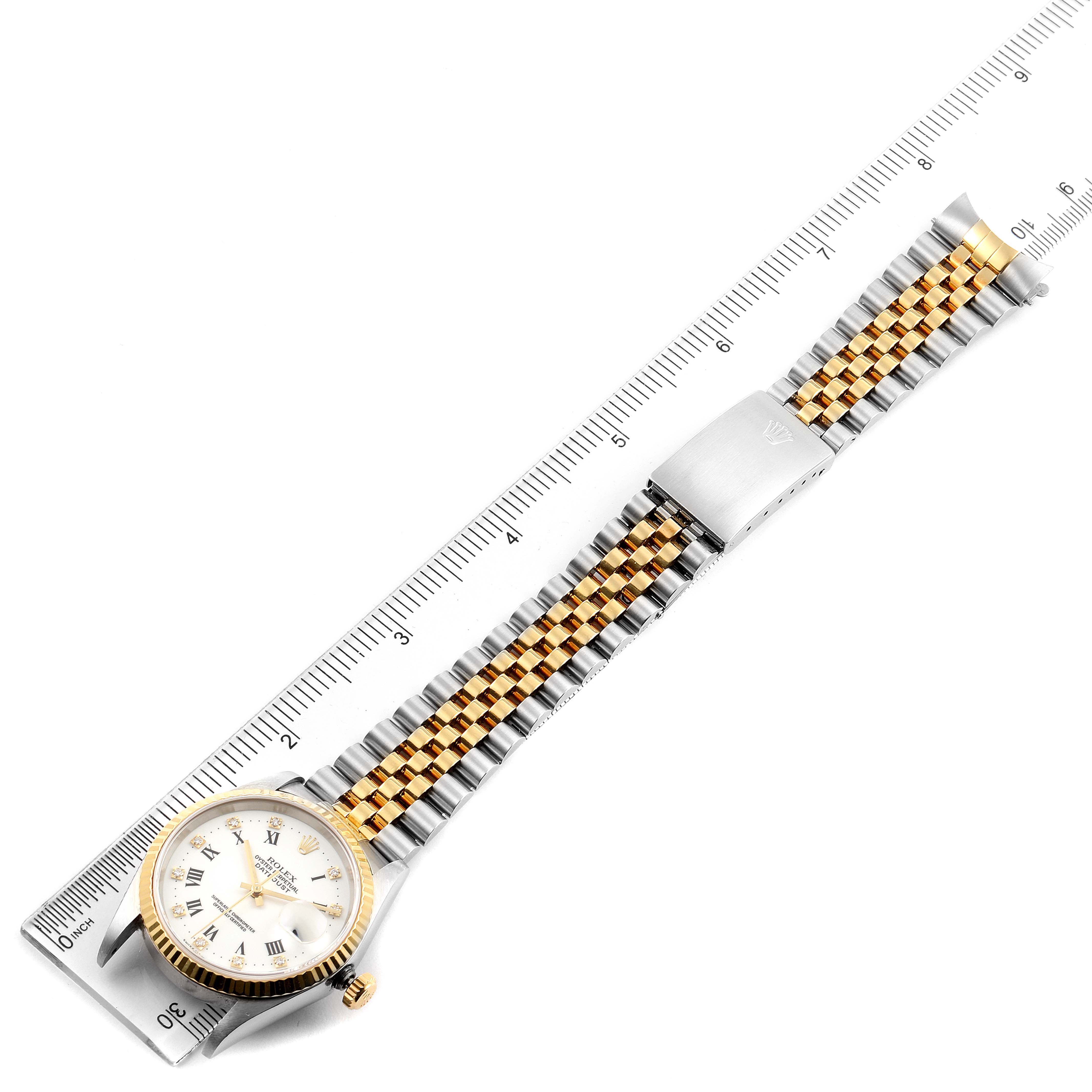 The image shows a top-down view of a Rolex Datejust 16233 Men's Steel and Gold (two tone) White Dial 16233 Men's Steel and Gold (two tone) White Dial watch alongside a measuring ruler, displaying the watch face and bracelet.