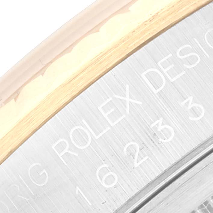 The image shows a close-up of the bezel and engraved inscription on the side of a Rolex Datejust 16233 Men's Steel and Gold (two tone) White Dial 16233 Men's Steel and Gold (two tone) White Dial watch.