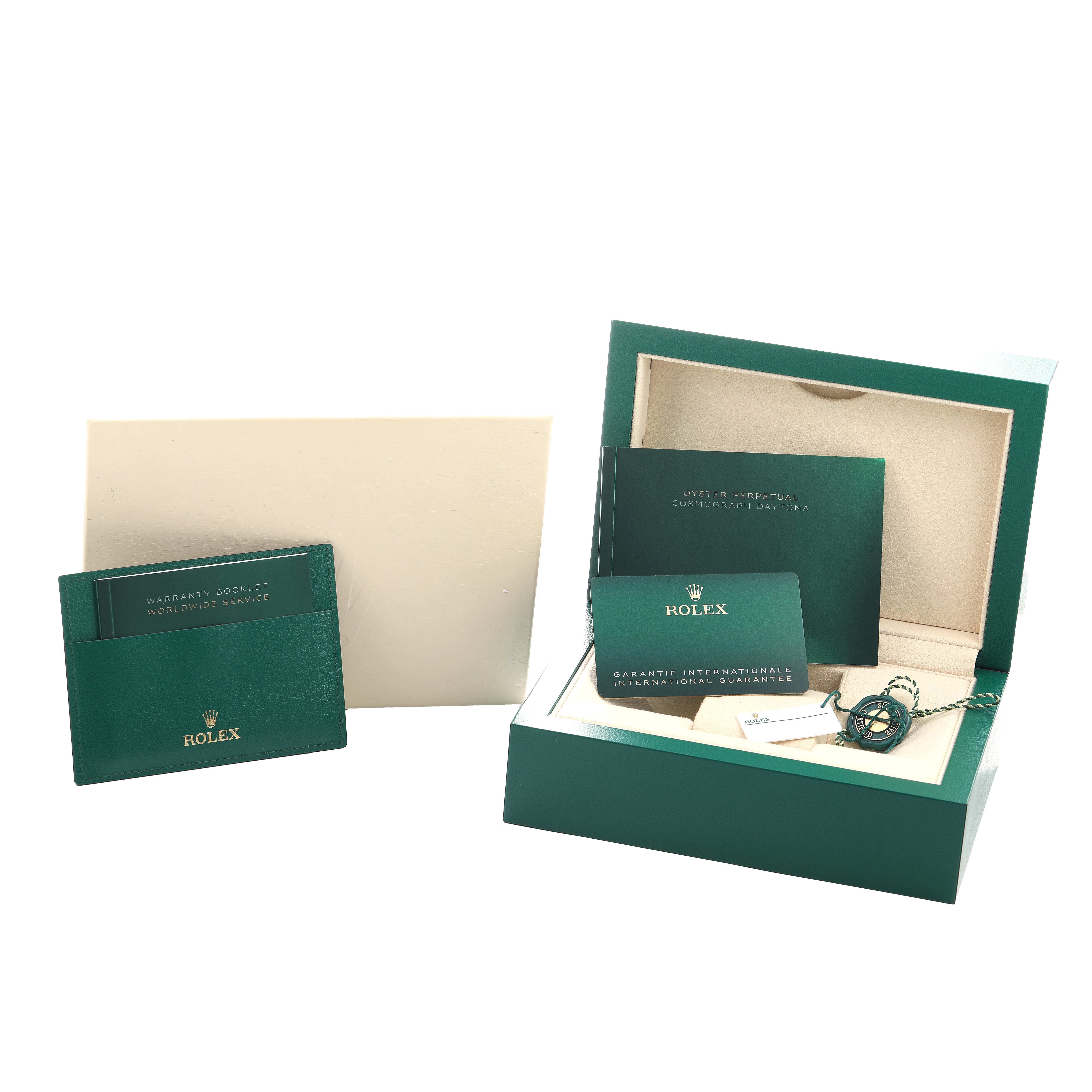 The image features the Rolex Daytona 116500LN Men's Stainless Steel Black Dial packaging with warranty booklets and a case from an overhead angle.