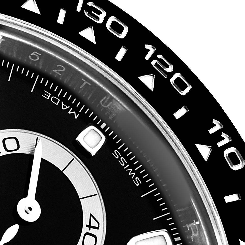 The image shows a close-up of the bezel and part of the dial on a Rolex Daytona 116500LN Men's Stainless Steel Black Dial, highlighting the tachymetric scale.