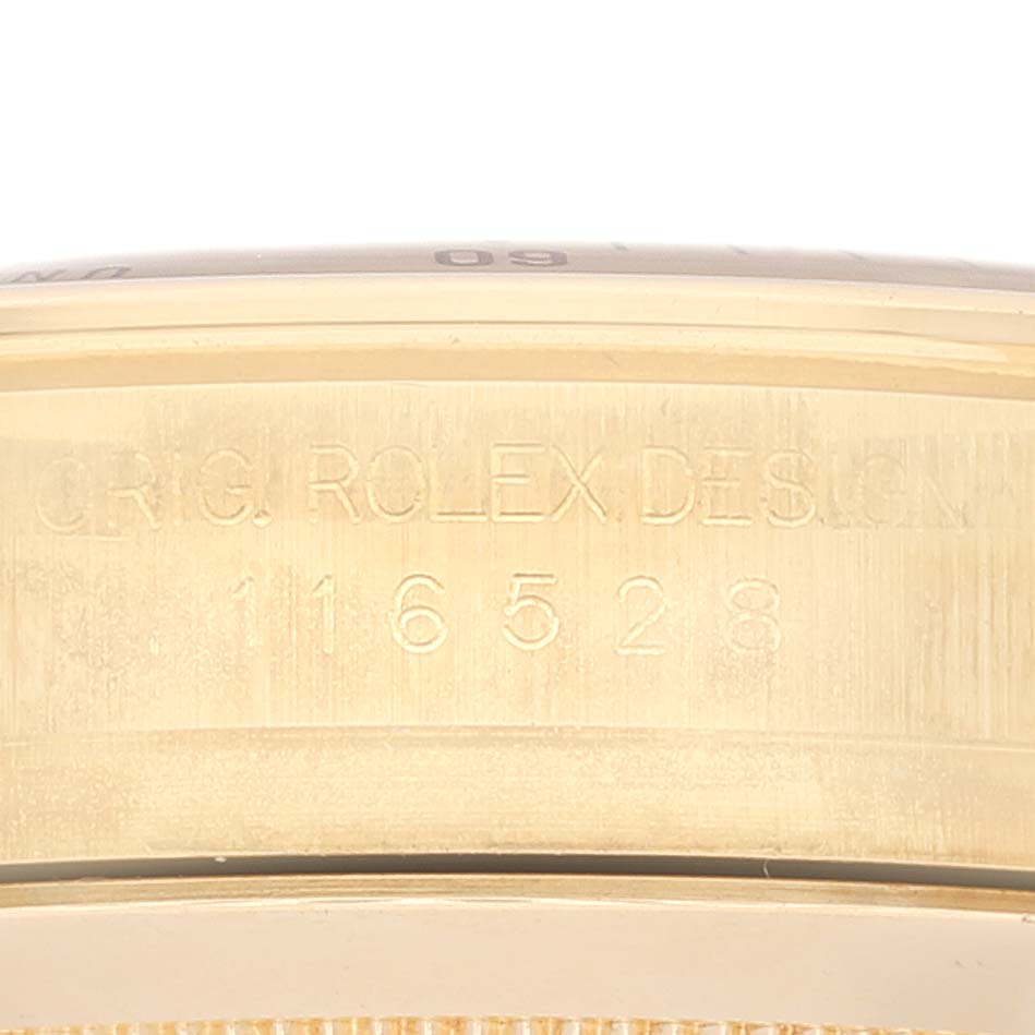 This image shows a close-up of the side of a Rolex Daytona 116528 Men's Yellow Gold Champagne Dial 116528 Men's Yellow Gold Champagne Dial watch case, highlighting the engraved design reference number "116528."