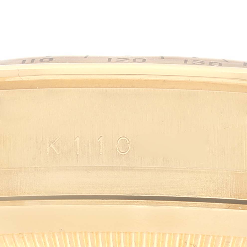 This is a close-up of the side of the case, showing the engraved number "K110" on a Rolex Daytona 116528 Men's Yellow Gold Champagne Dial 116528 Men's Yellow Gold Champagne Dial watch.