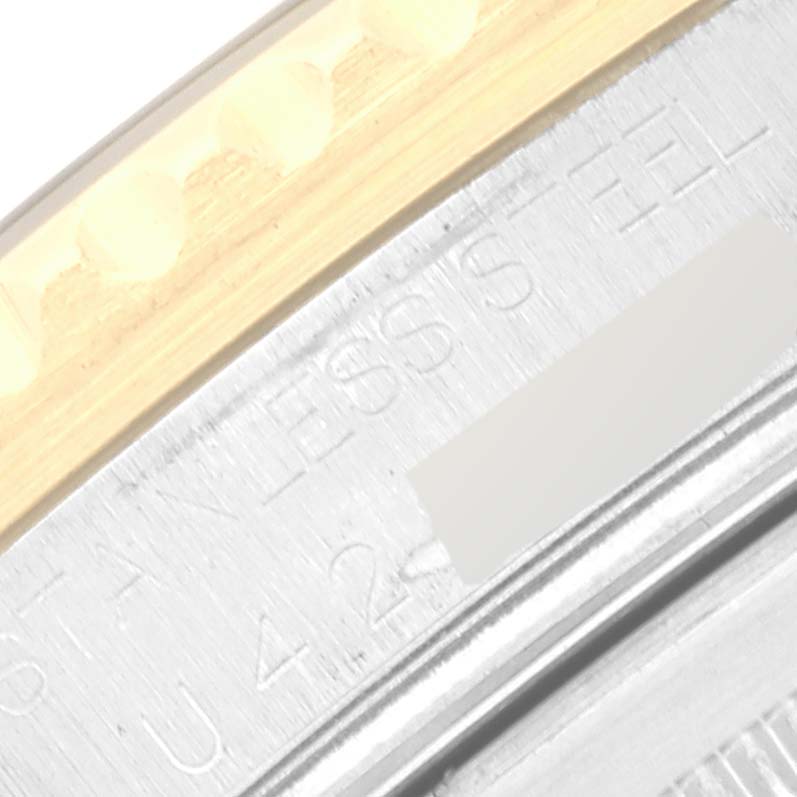 This close-up image shows part of the bezel and case, as well as the engraved text on a Rolex GMT-Master 16713 Men's Steel and Gold (two tone) Black Dial 16713 Men's Steel and Gold (two tone) Black Dial watch.