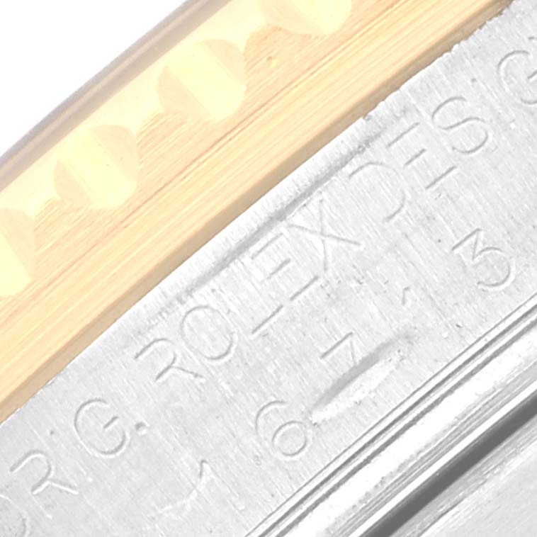 Close-up view showing the side engraving and partial bezel of a Rolex GMT-Master 16713 Men's Steel and Gold (two tone) Black Dial 16713 Men's Steel and Gold (two tone) Black Dial watch.