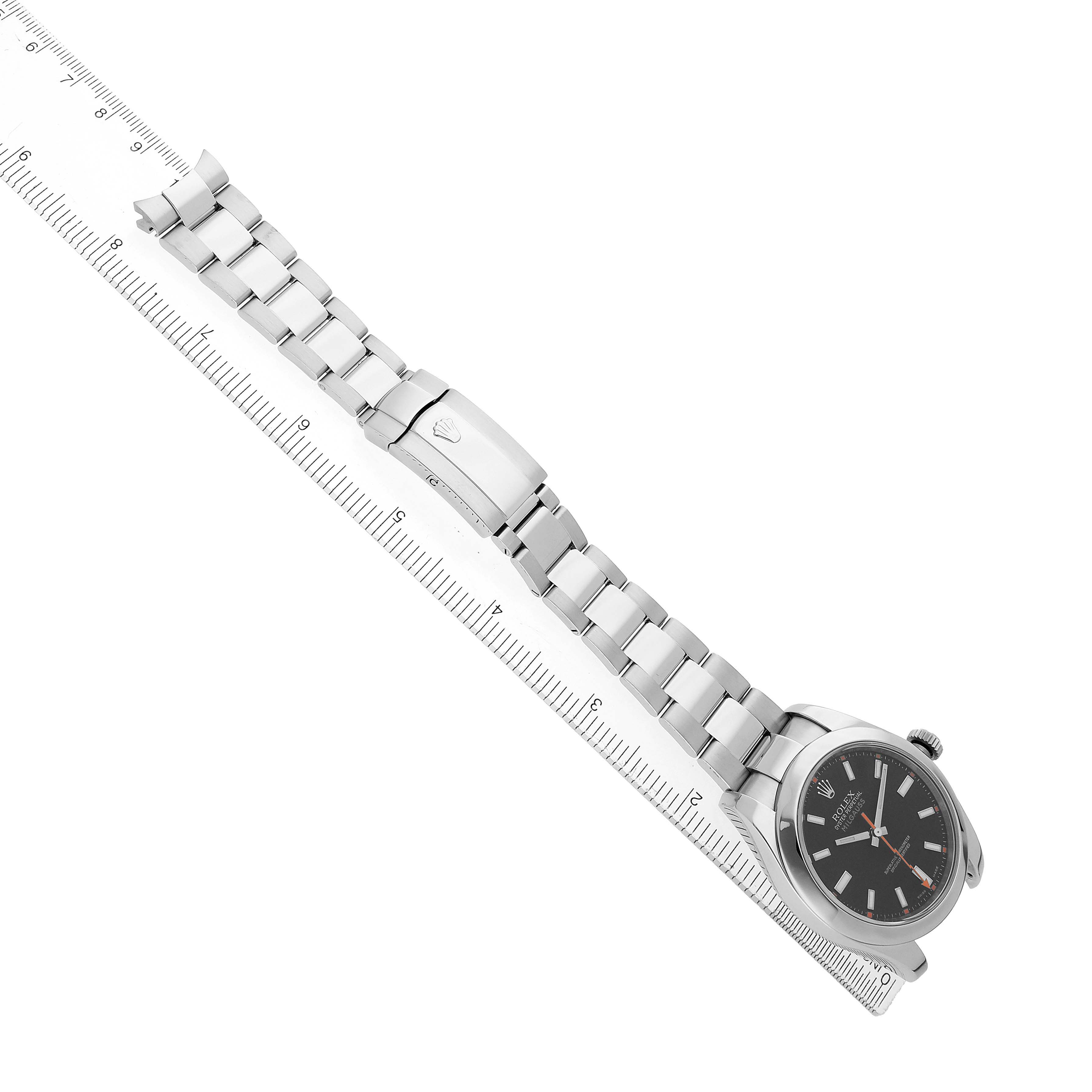 The Rolex Milgauss 116400 Men's Stainless Steel Black Dial watch is shown at an angle, highlighting the face, bracelet, and clasp along a ruler.
