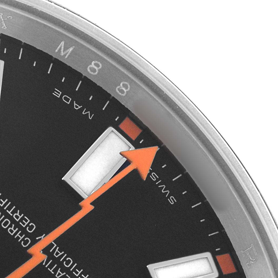 This close-up image shows part of the dial, an hour marker, and the orange lightning bolt second hand of the Rolex Milgauss 116400 Men's Stainless Steel Black Dial watch.
