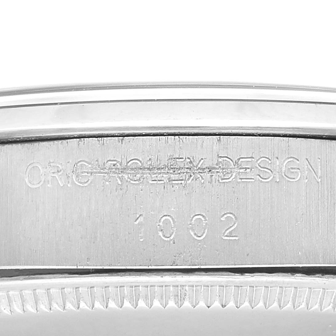 The image shows a close-up of the case side of the Rolex Vintage Collection 1002 Men's Stainless Steel Silver Dial 1002 Men's Stainless Steel Silver Dial model with engraved text.