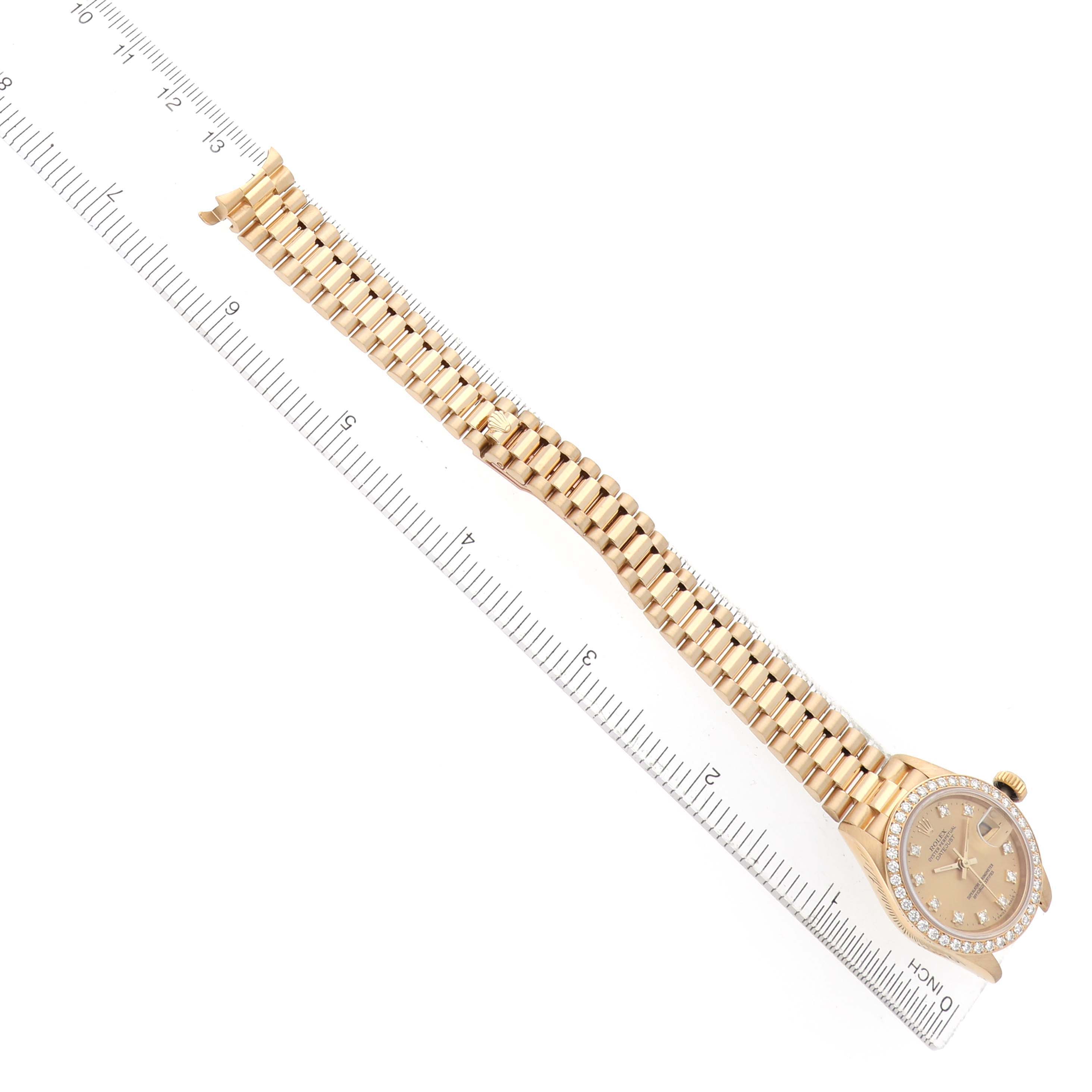 The Rolex President 69138 Women's Yellow Gold Champagne Dial model watch is displayed from an overhead angle, showcasing its bracelet and diamond-encrusted bezel.