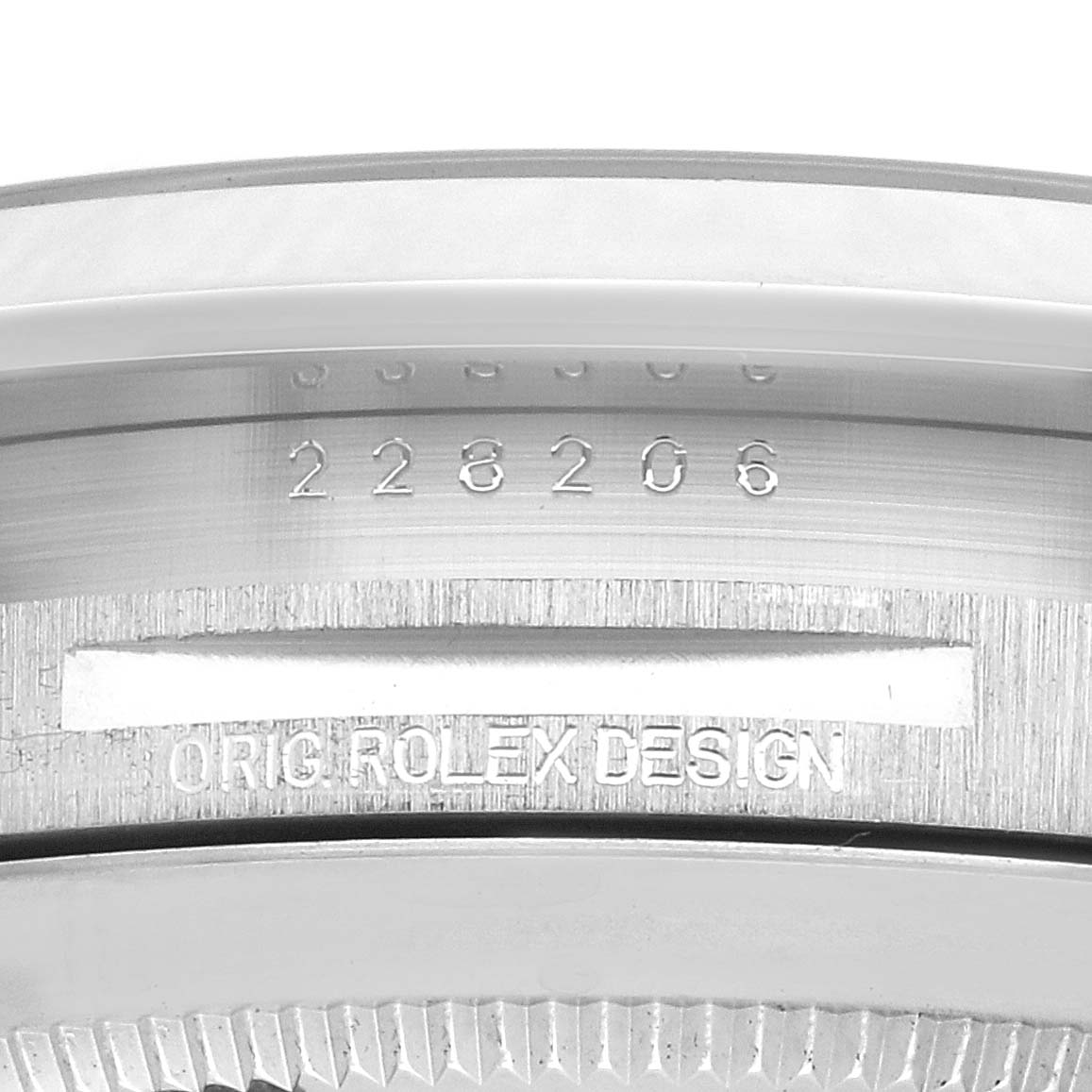 The image shows the edge of a Rolex President 228206 Men's Platinum Green Dial model, focusing on the serial engraving on the watch case.