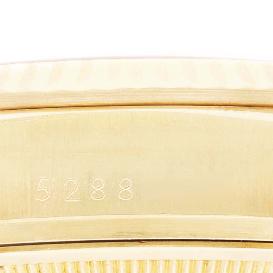 The image shows a close-up of the edge and side of a Rolex President 18038 Men
s Yellow Gold Champagne Dial 18038 Men
s Yellow Gold Champagne Dial watch, with engraved numbers visible.