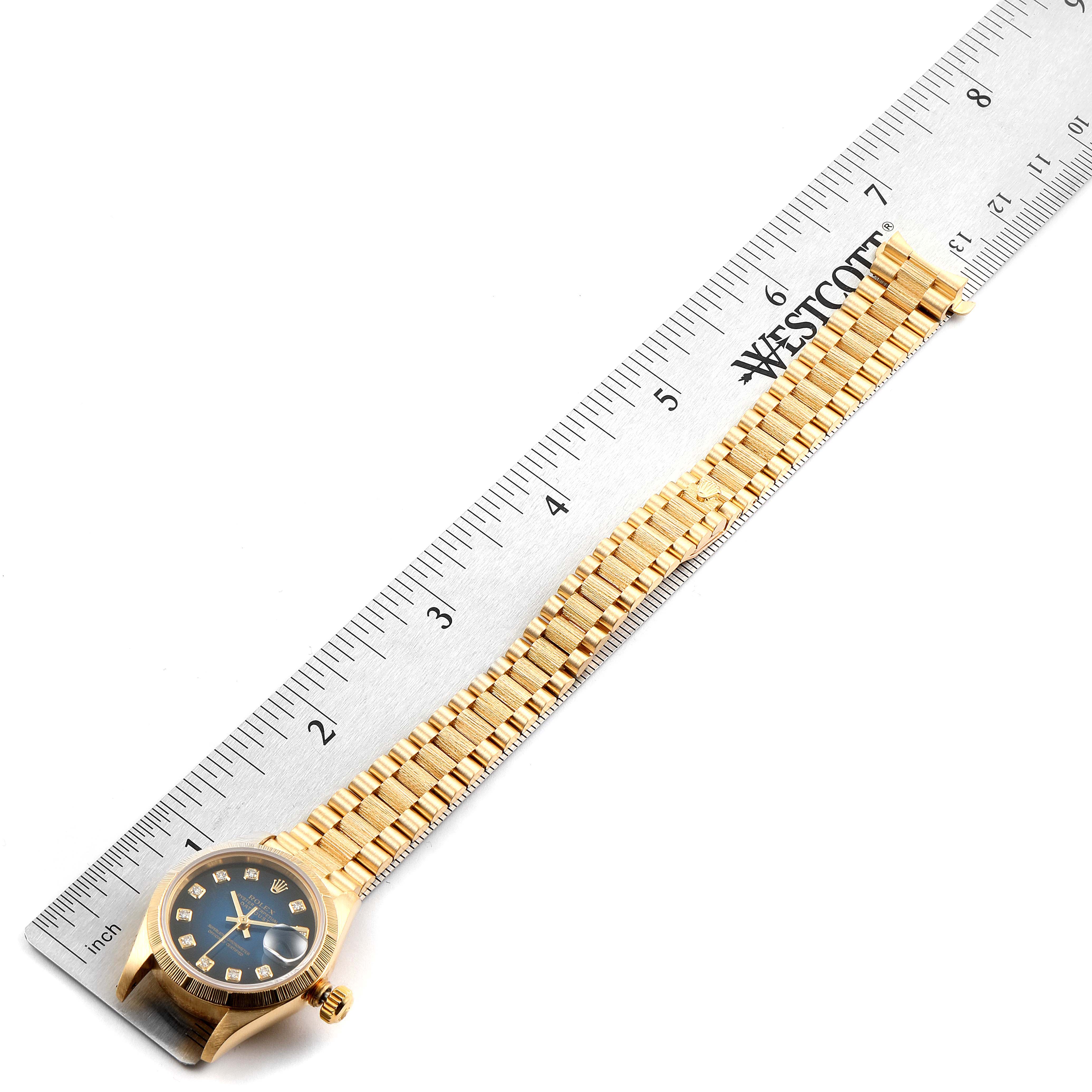 The image shows a Rolex President 69278 Women's Yellow Gold Blue Dial 69278 Women's Yellow Gold Blue Dial watch lying flat alongside a metal ruler, displaying its face and full bracelet.