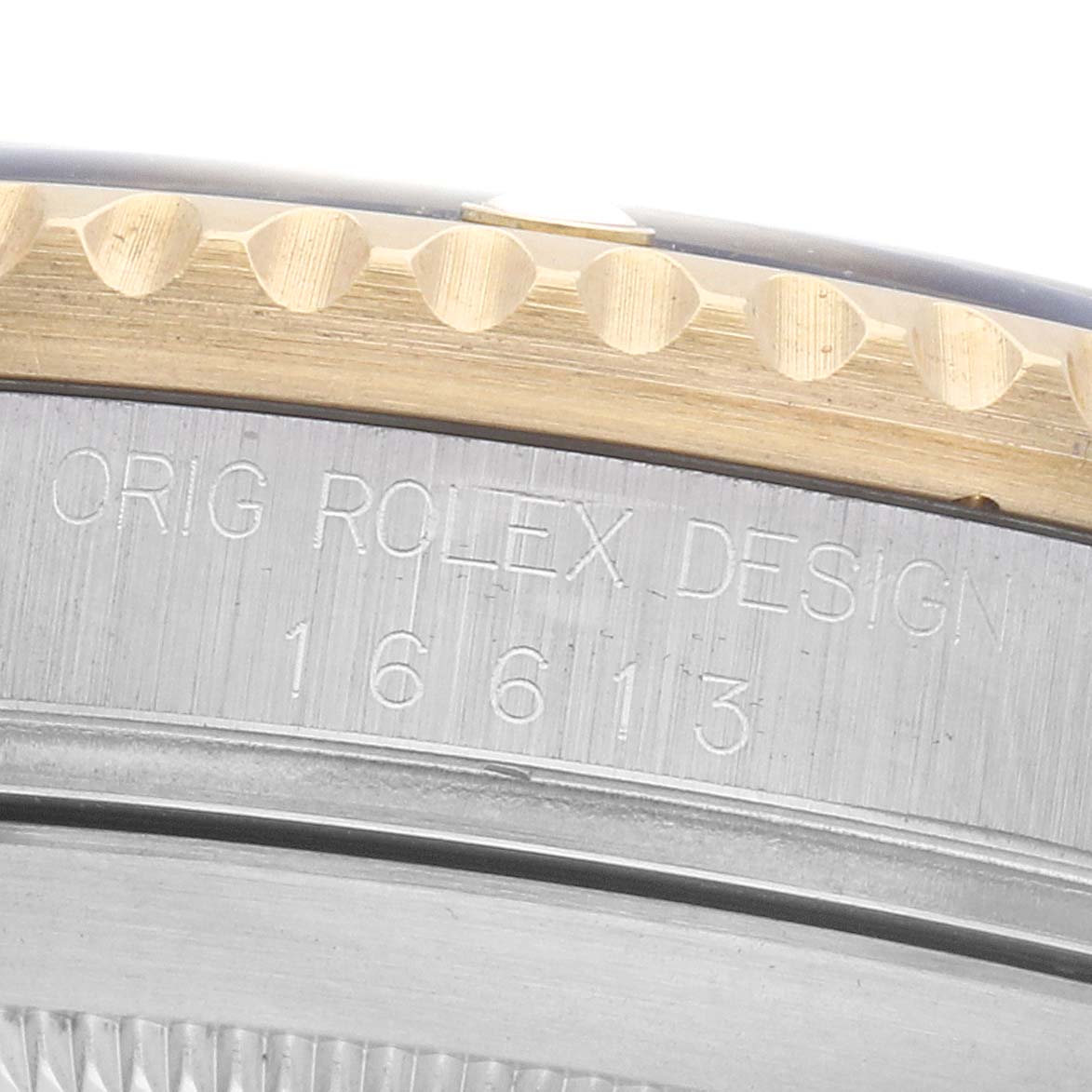 The image shows a close-up of the Rolex Submariner 16613 Men's Steel and Gold (two tone) Blue Dial bezel and case edge, highlighting the engraved model number and branding.