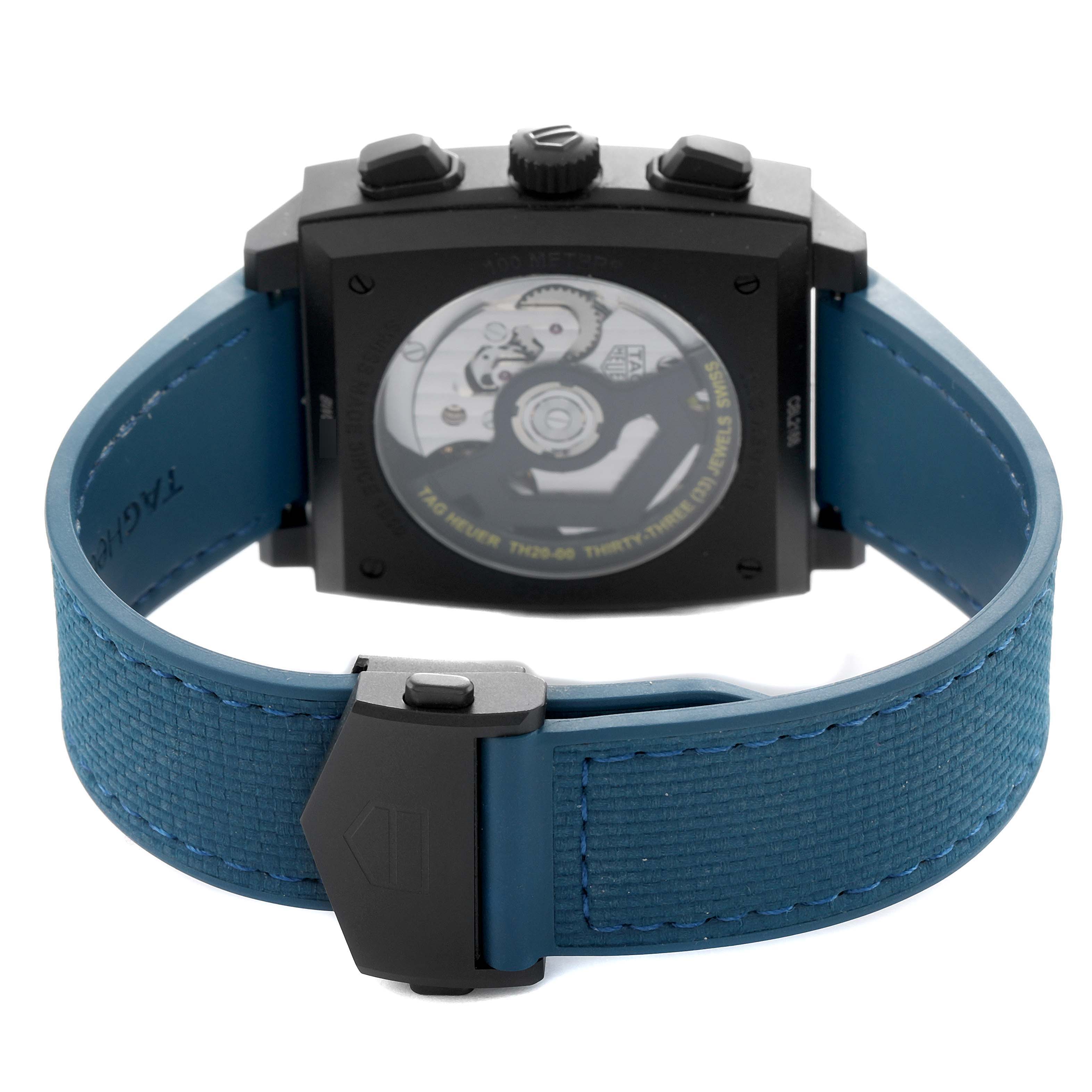 The Tag Heuer Monaco CBL2188.FT6261 Men's Titanium Blue Dial watch is shown from the back, displaying its movement and blue strap with a clasp.