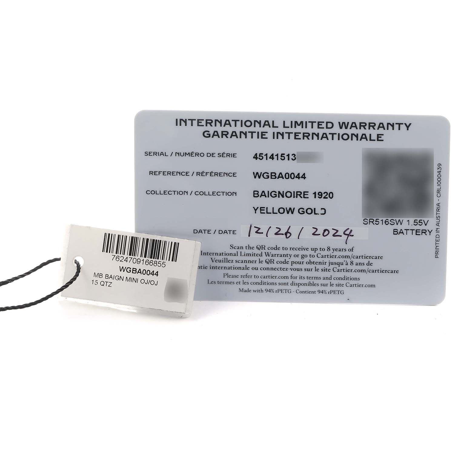 The image shows a Cartier Baignoire WGBA0044 Women's Yellow Gold Silver Dial warranty card and a tag, photographed from above.