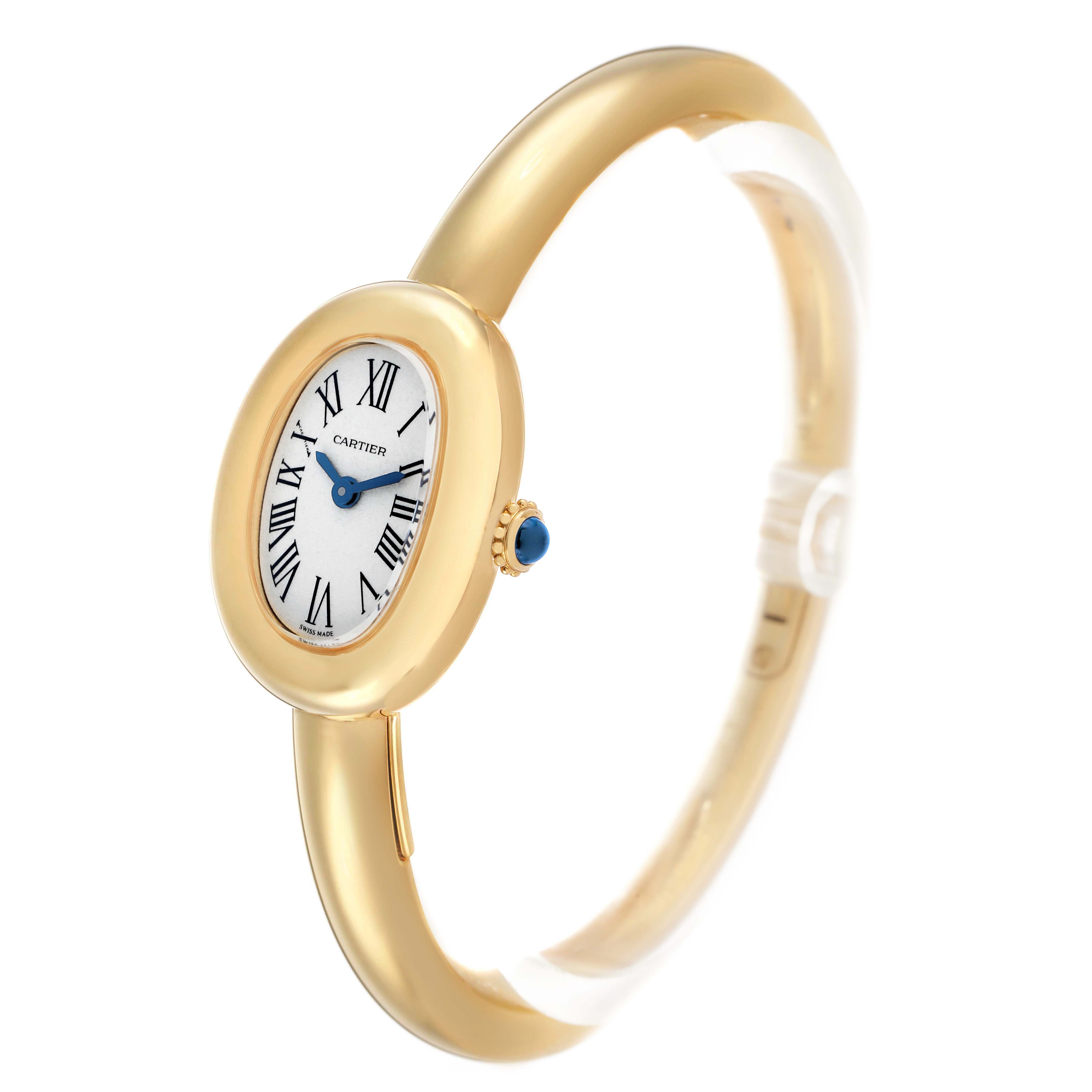 The Cartier Baignoire WGBA0044 Women's Yellow Gold Silver Dial watch is shown at a slight angle, highlighting its oval face, Roman numerals, blue hands, and gold bracelet.