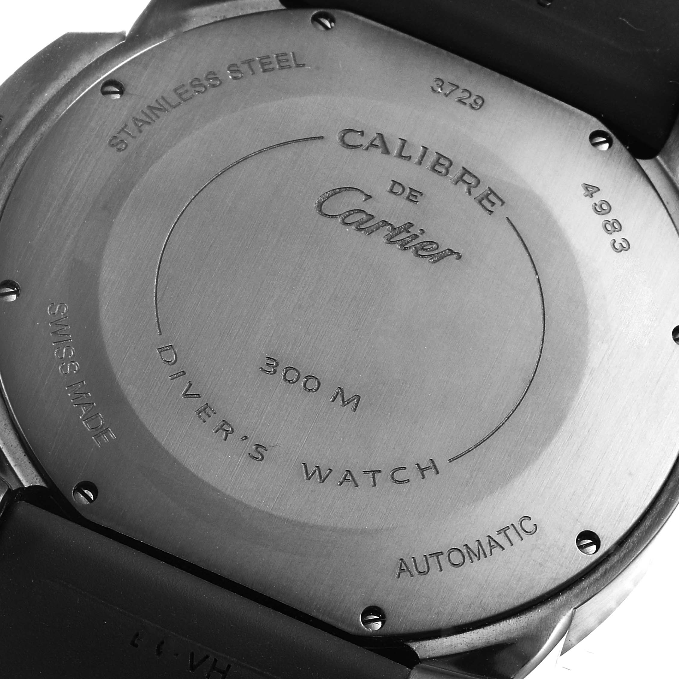 The image shows the back case of a Calibre de Cartier model by Cartier, displaying text details and screws.