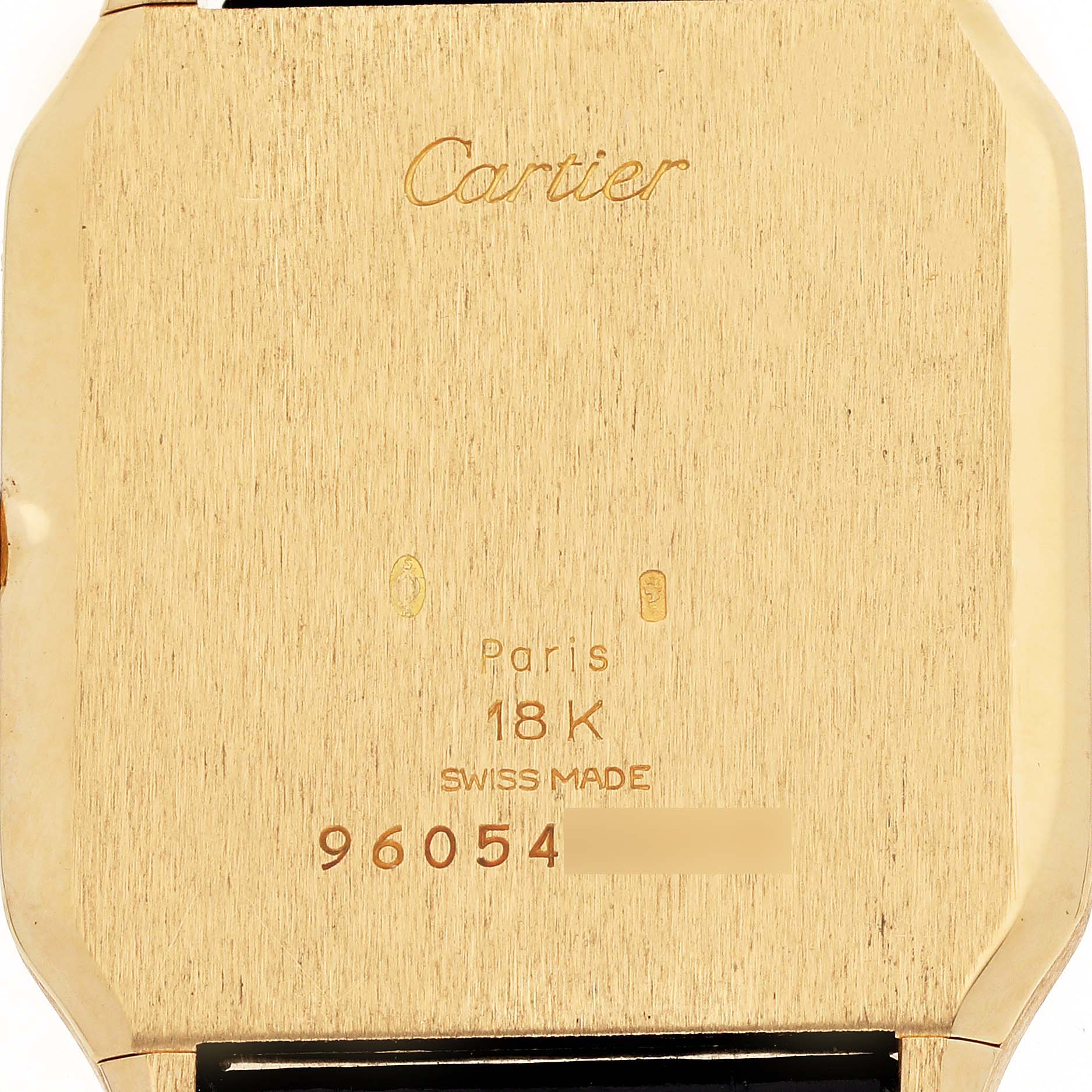 The image shows the back of a Cartier Santos Dumont 15751 Men's Yellow Gold White Dial 15751 Men's Yellow Gold White Dial watch, featuring engravings including the brand name and material details.