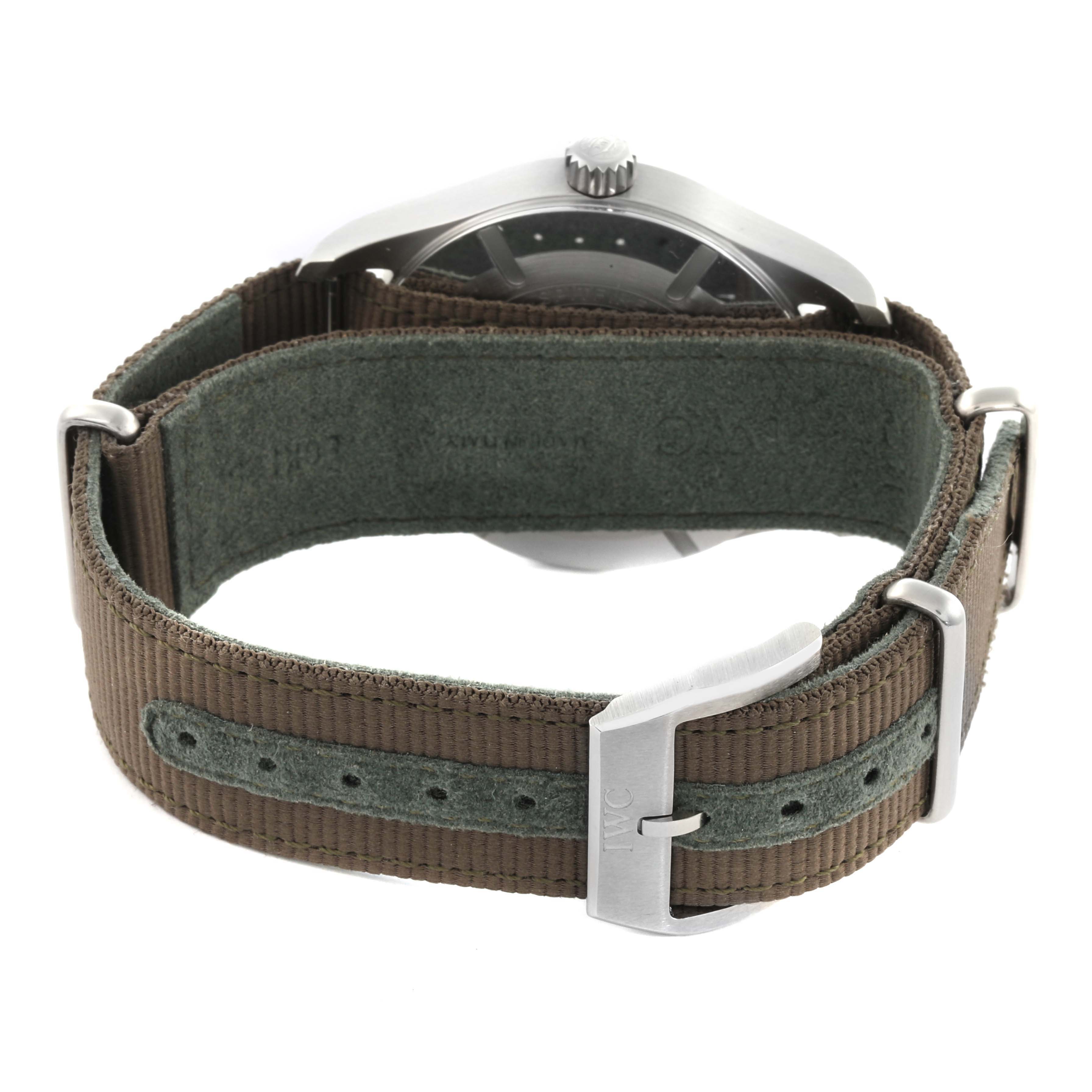 The image shows the back view of an IWC Pilot IW326801 Men's Stainless Steel Black Dial IW326801 Men's Stainless Steel Black Dial watch with a green fabric strap and silver buckle.